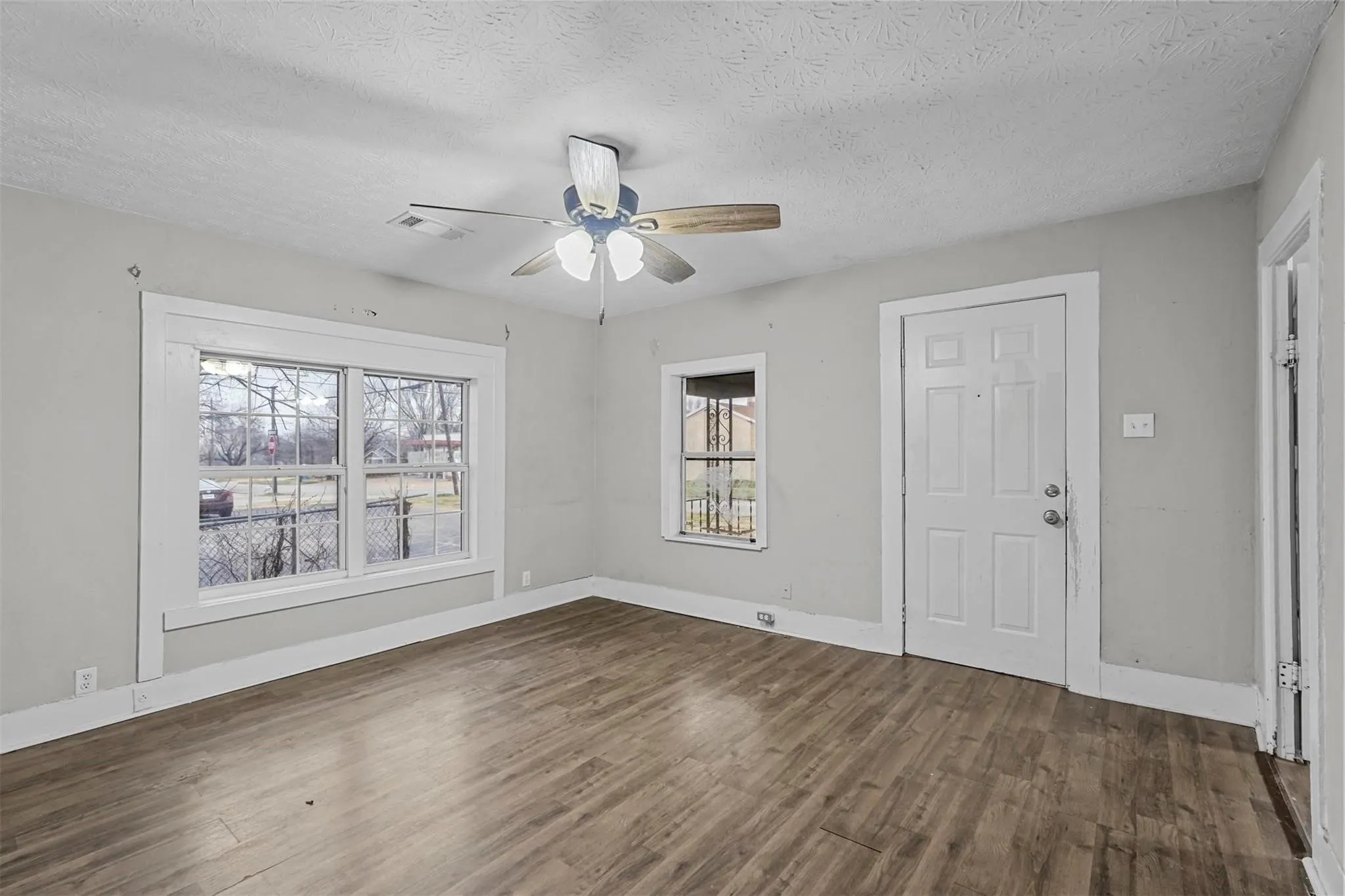 Foyer with a textured ceiling, dark wood-type flooring, and a ceiling fan