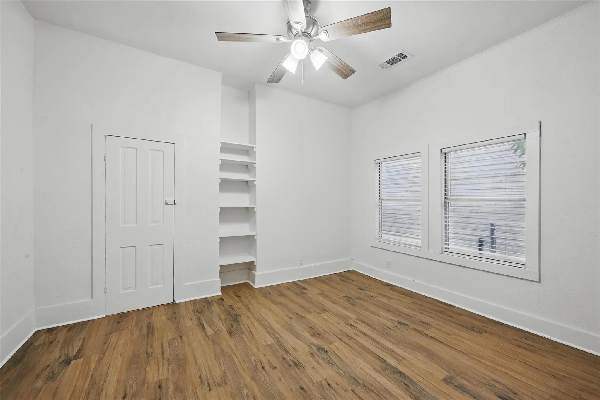 Unfurnished bedroom with wood finished floors and a ceiling fan