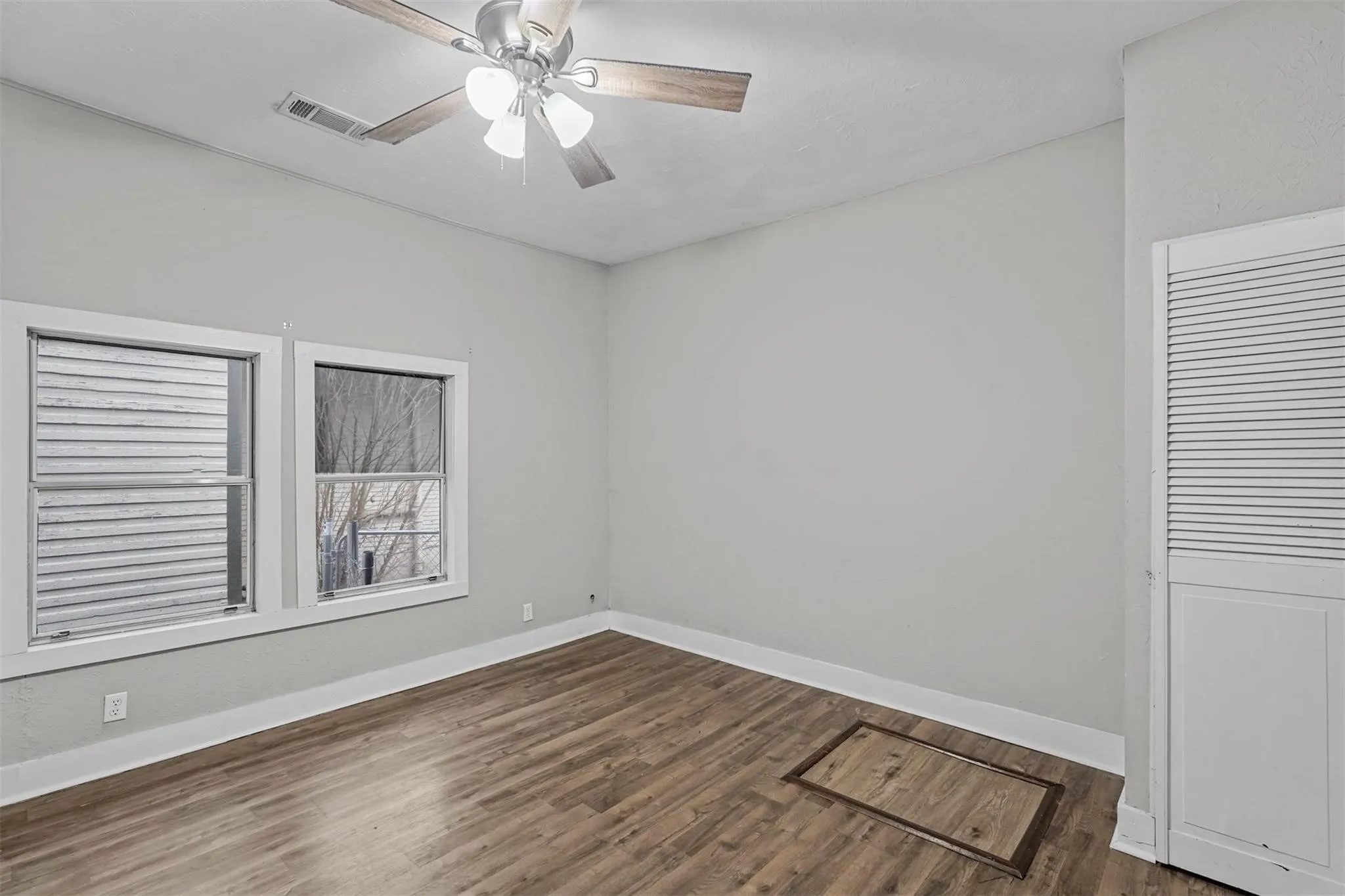 Empty room featuring dark wood-style flooring and ceiling fan