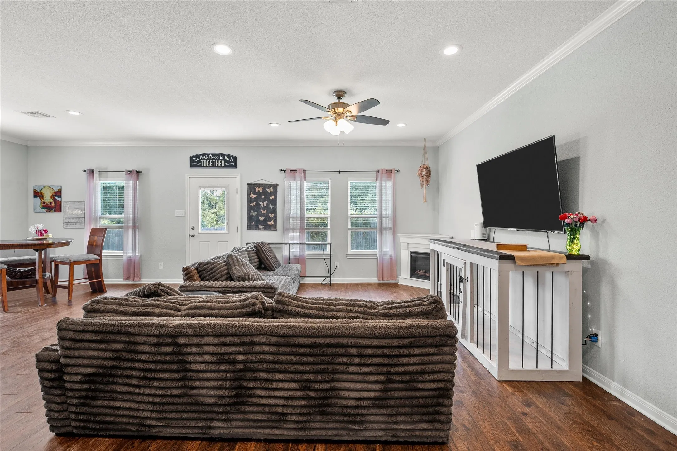 Open-concept living area featuring wood-finish flooring, recessed lighting, and a ceiling fan