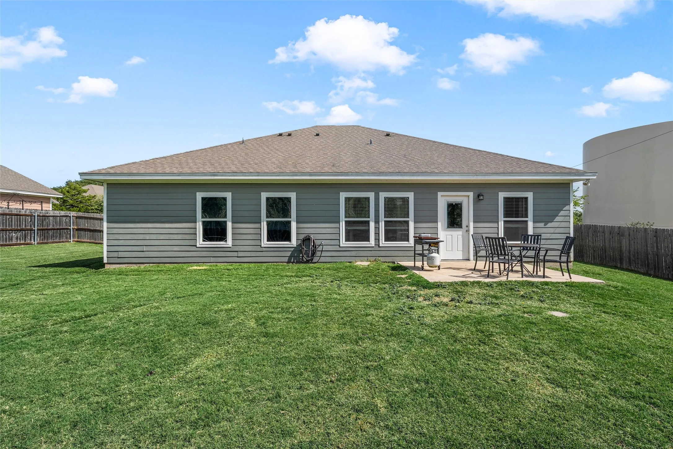 Expansive backyard featuring a concrete patio and a privacy fence