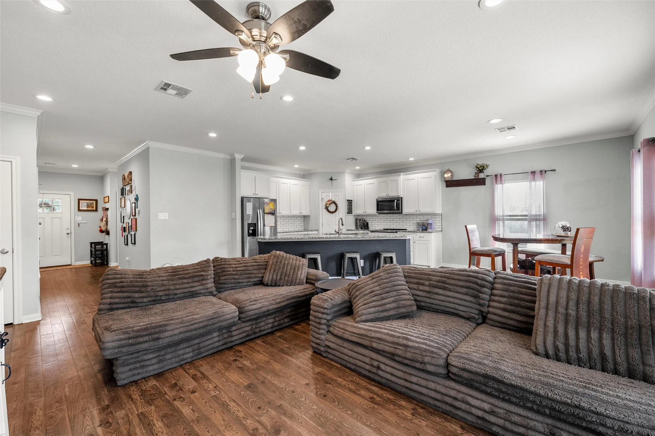 Living area featuring wood-finish flooring, recessed lighting, and a ceiling fan