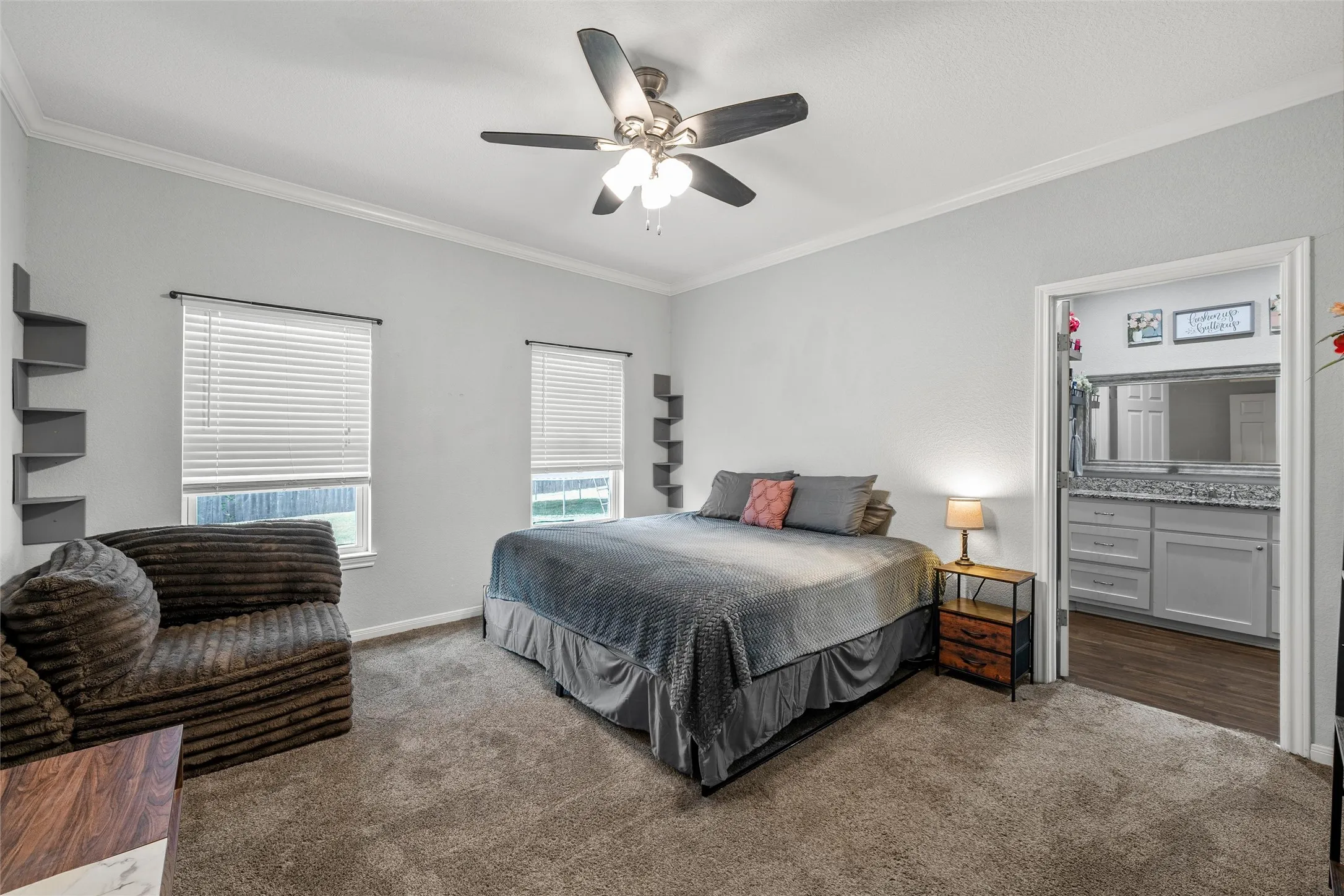 Spacious room featuring carpet flooring, crown molding, and two windows with blinds
