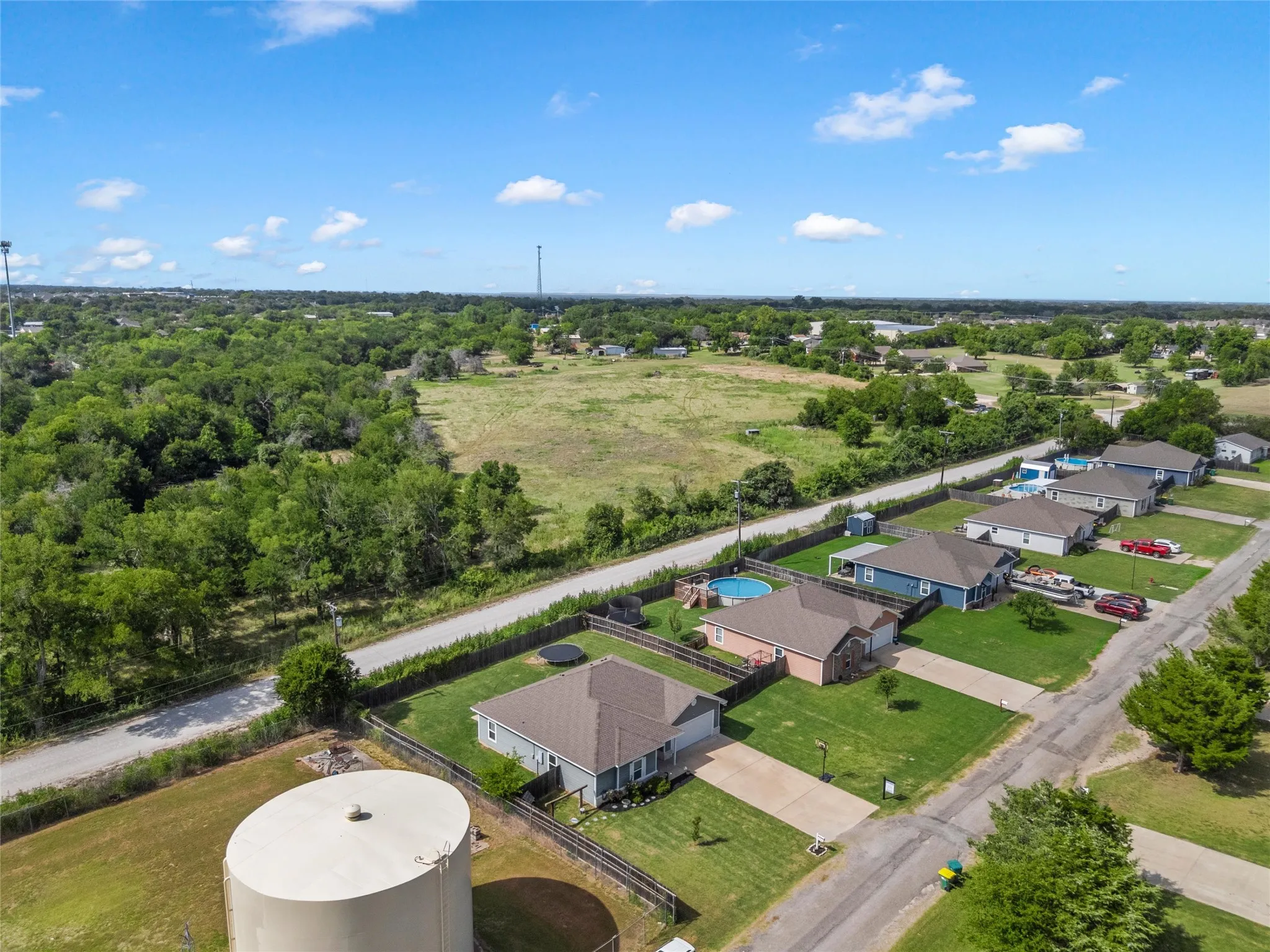 Aerial perspective showcasing a residential community with individual properties, each featuring a private yard and paved driveway