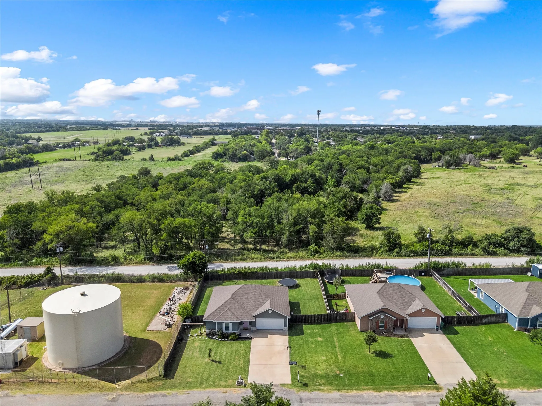 Aerial perspective showcasing a residential property with a brown-shingled roof and an attached two-car garage