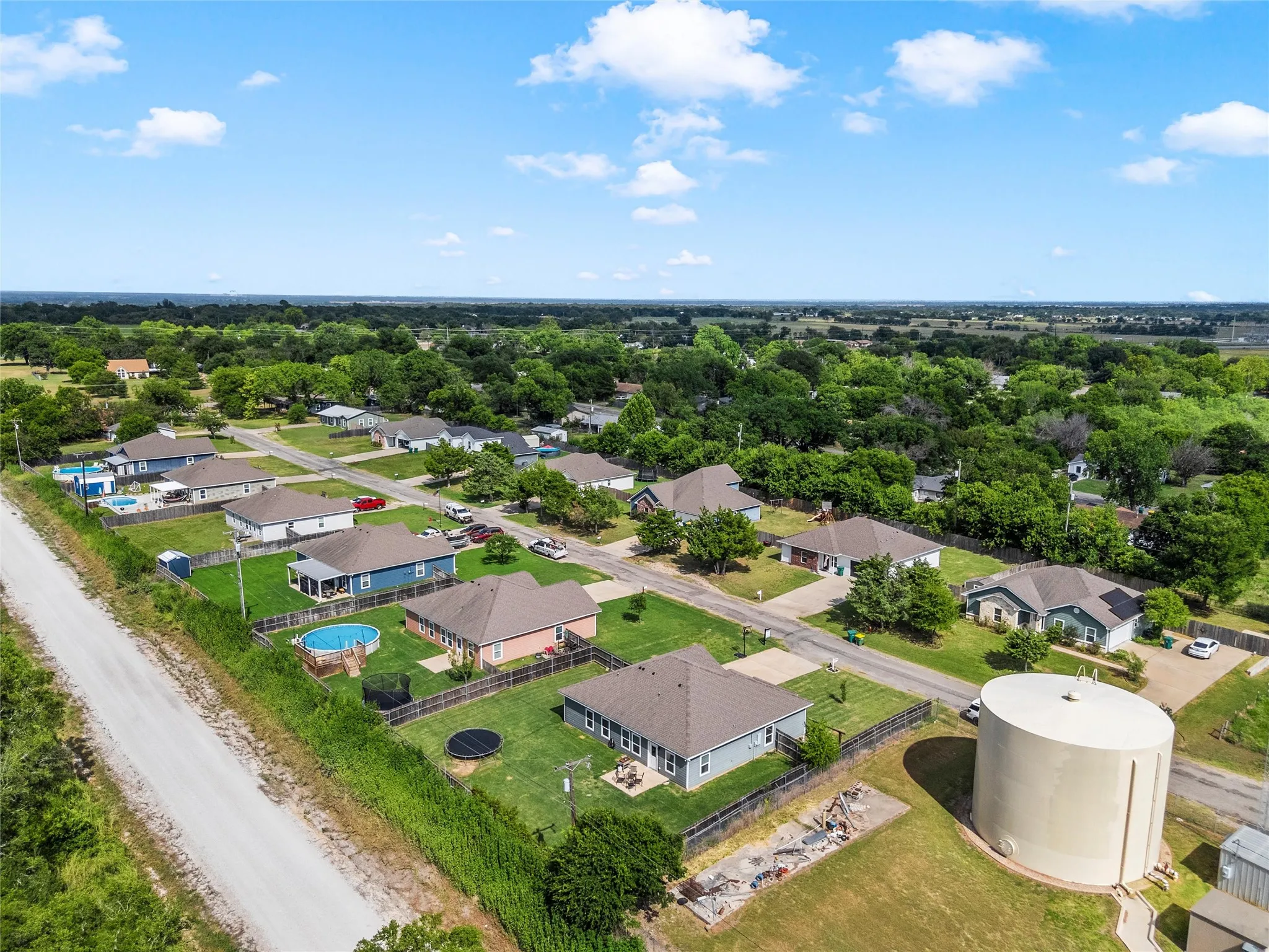 Aerial perspective showcasing a residential community with single-story homes and mature tree coverage