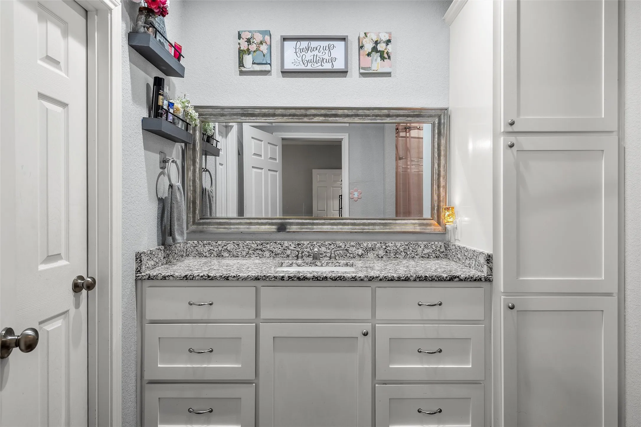 Bathroom vanity with a single basin, granite countertop, shaker-style cabinetry, and a full-width framed mirror