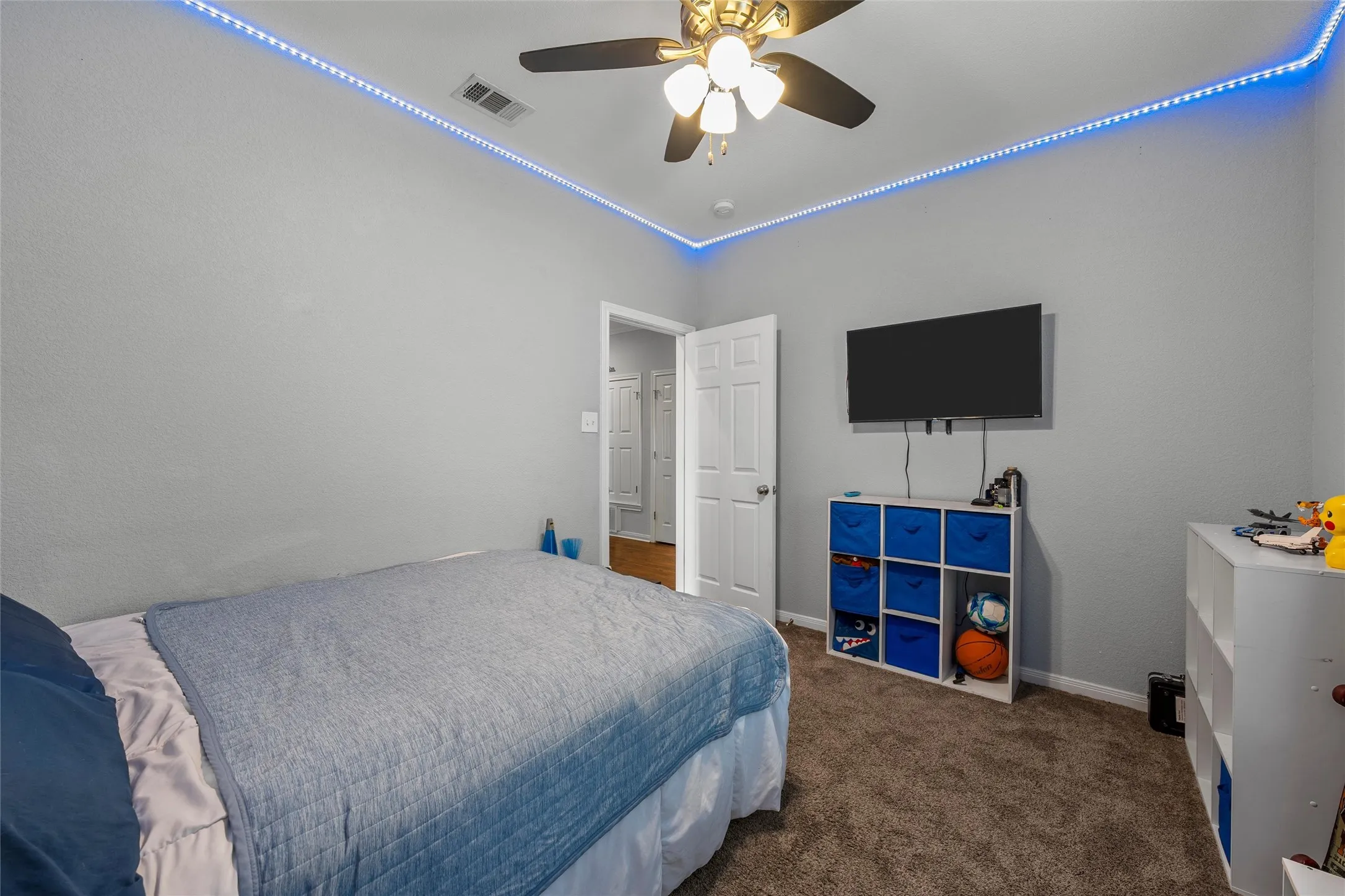Spacious room featuring neutral grey walls and dark brown carpeting