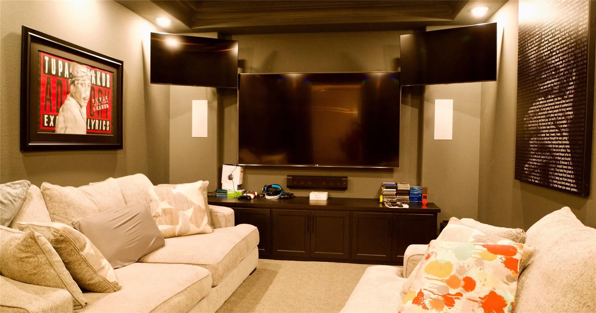 Dedicated media room featuring tray ceiling, recessed lighting, and wall-mounted speakers