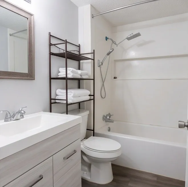 Bathroom featuring a single vanity with wood-finish cabinetry, a white basin, and a framed mirror