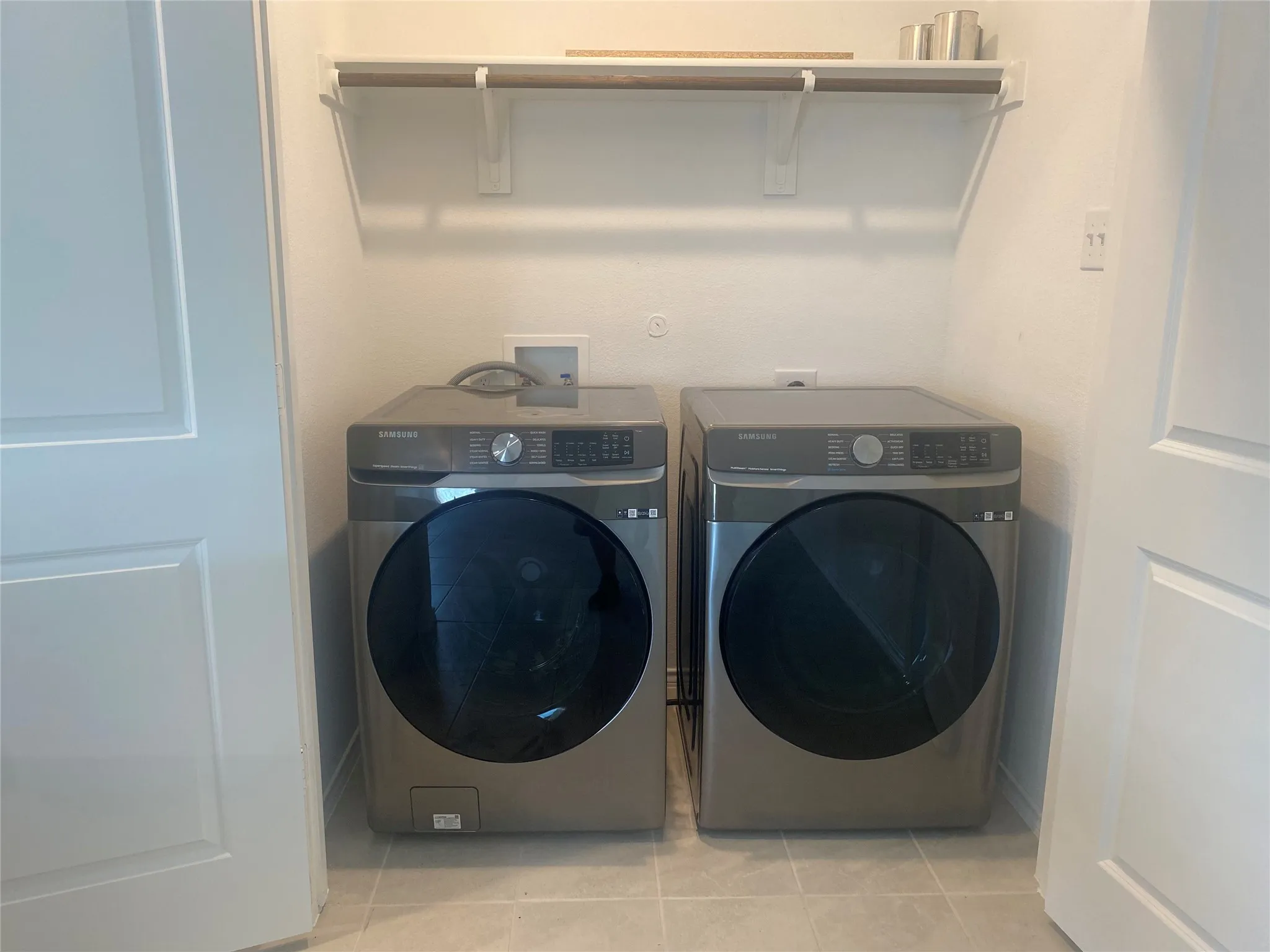 Laundry room featuring washing machine and dryer and light tile patterned floors