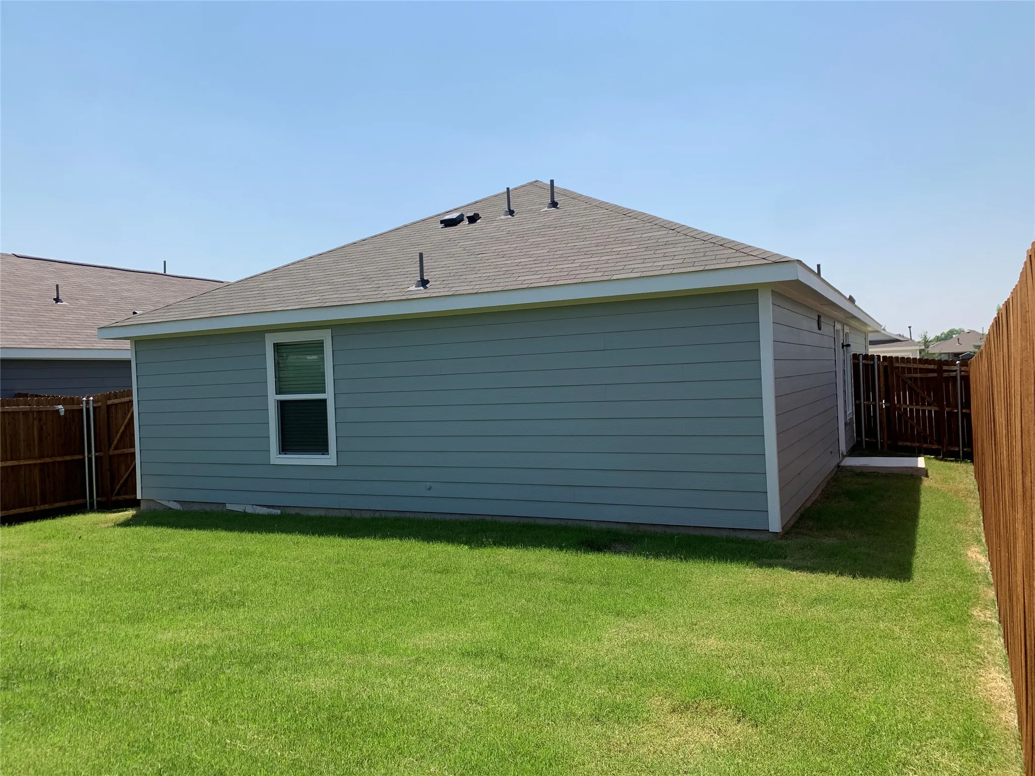 Rear view of house featuring a large back yard