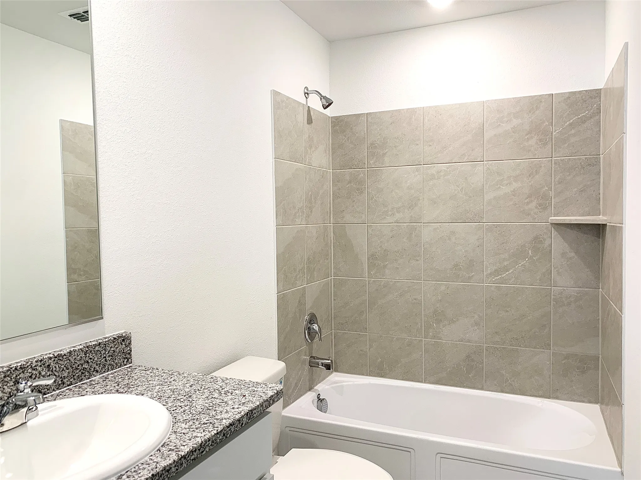 Full bathroom featuring vanity, tiled shower