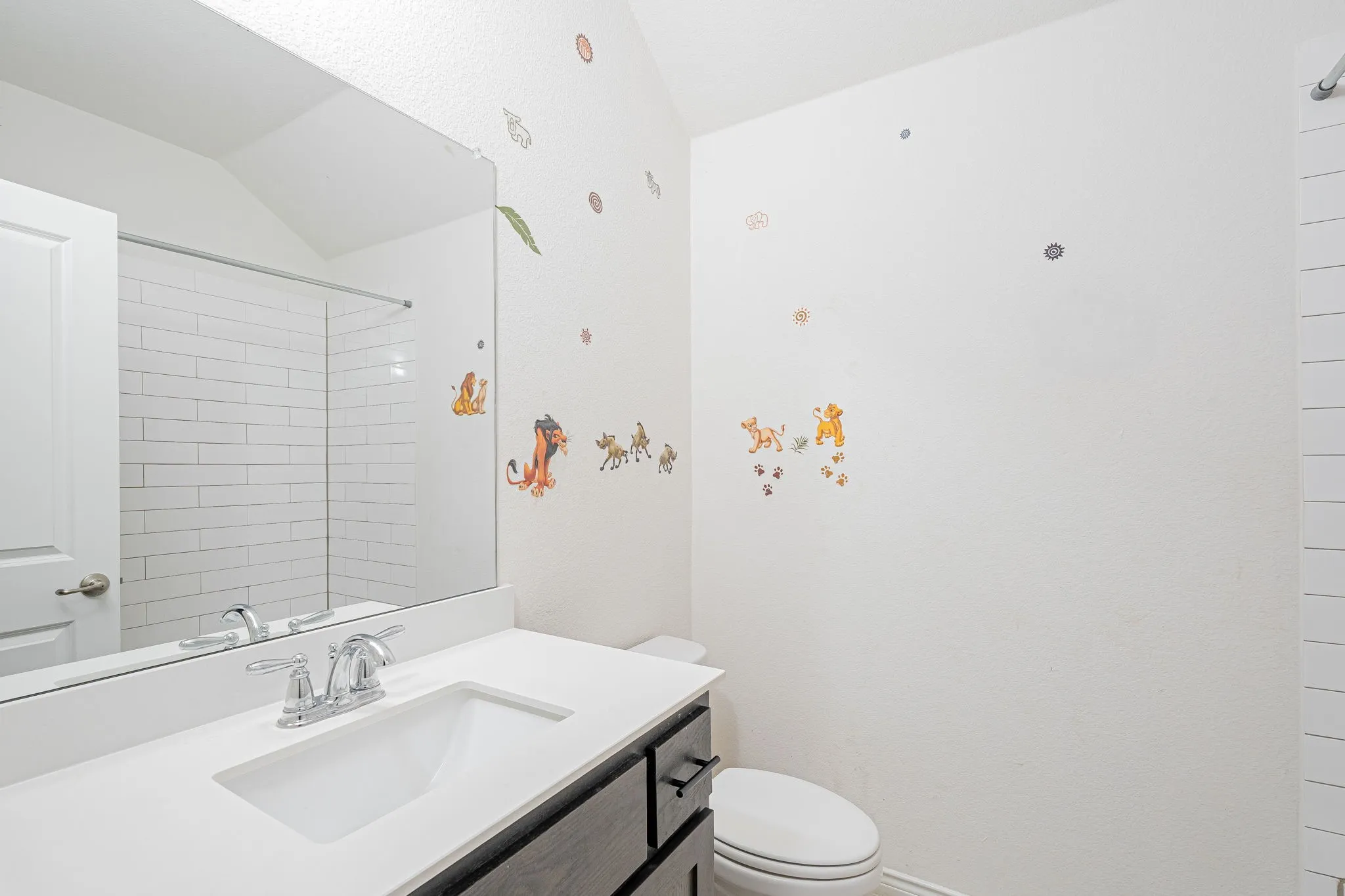 Full bathroom with lofted ceiling, vanity, and a shower