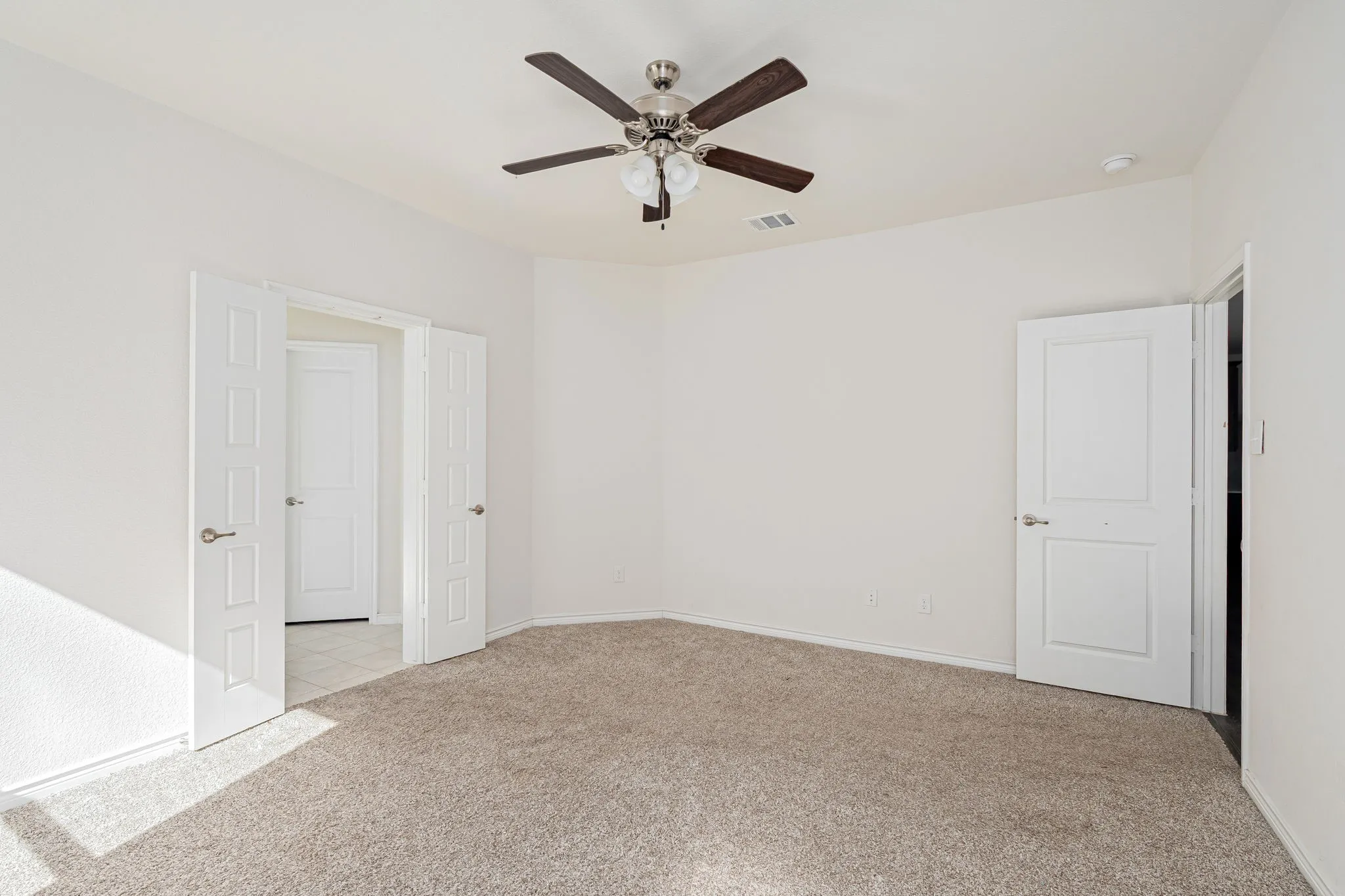 Unfurnished room with light colored carpet and ceiling fan