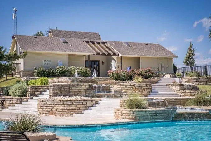 Outdoor swimming pool with integrated waterfall features and stone-clad retaining walls