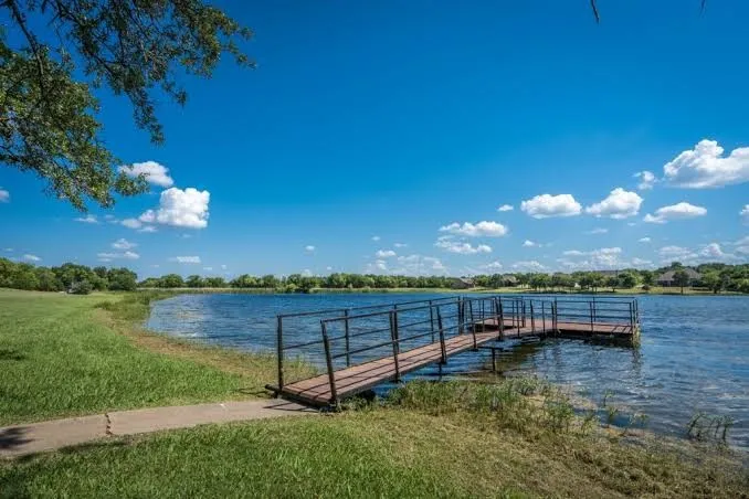 Lakeside property featuring a private dock with metal railings extending over the water