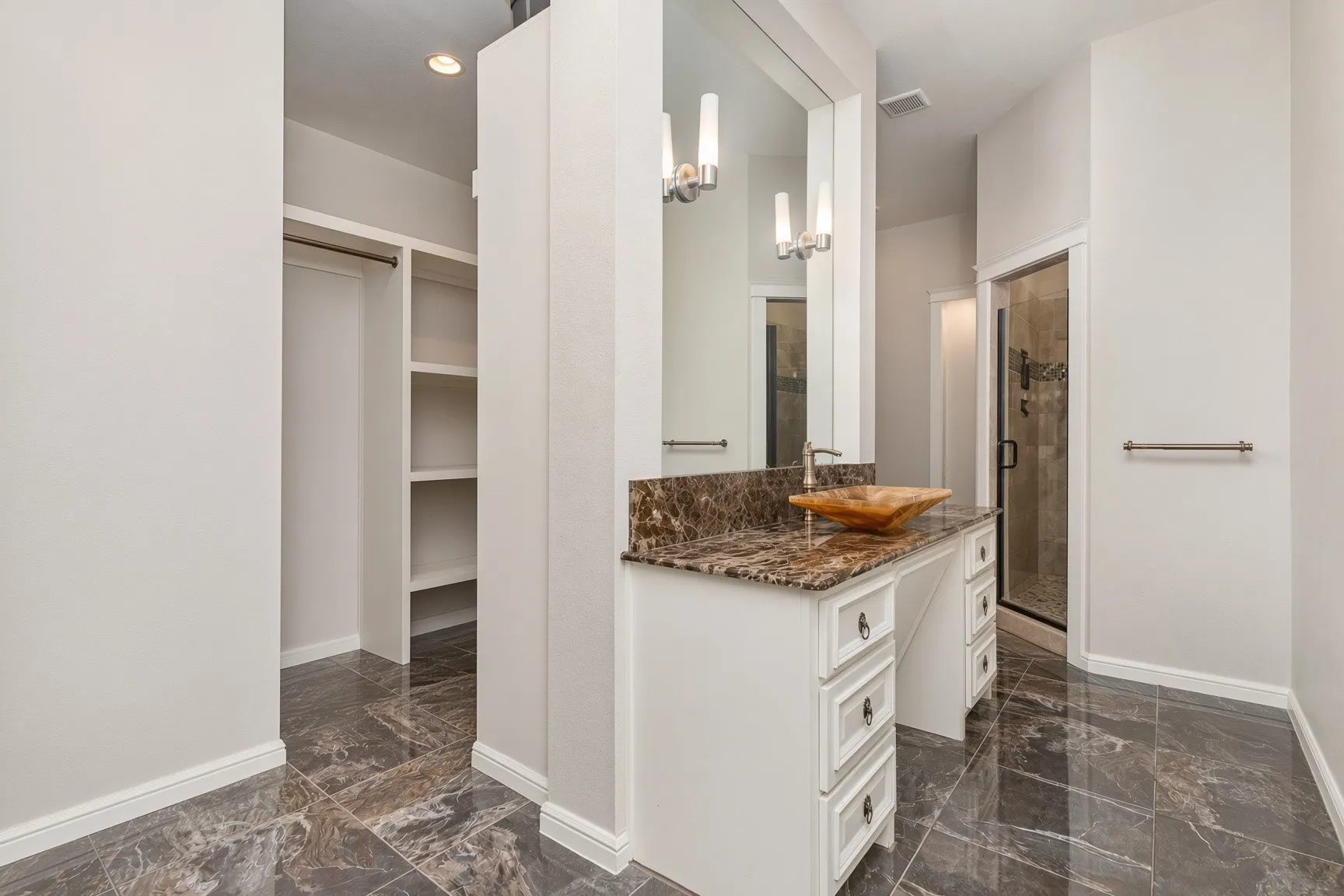 Vanity with a vessel sink, brown granite countertop, and white cabinetry with drawer storage