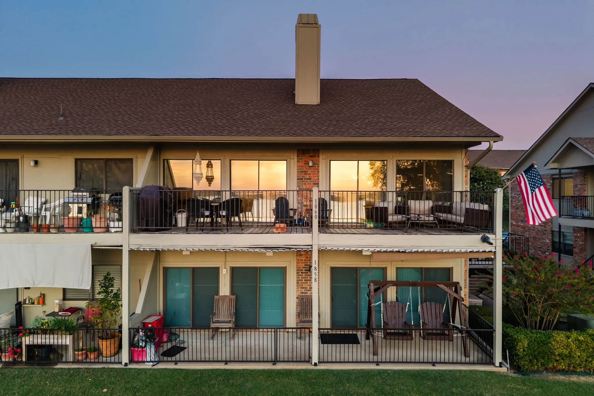 Two-story structure with an upper-level balcony featuring dark railing and sliding glass doors
