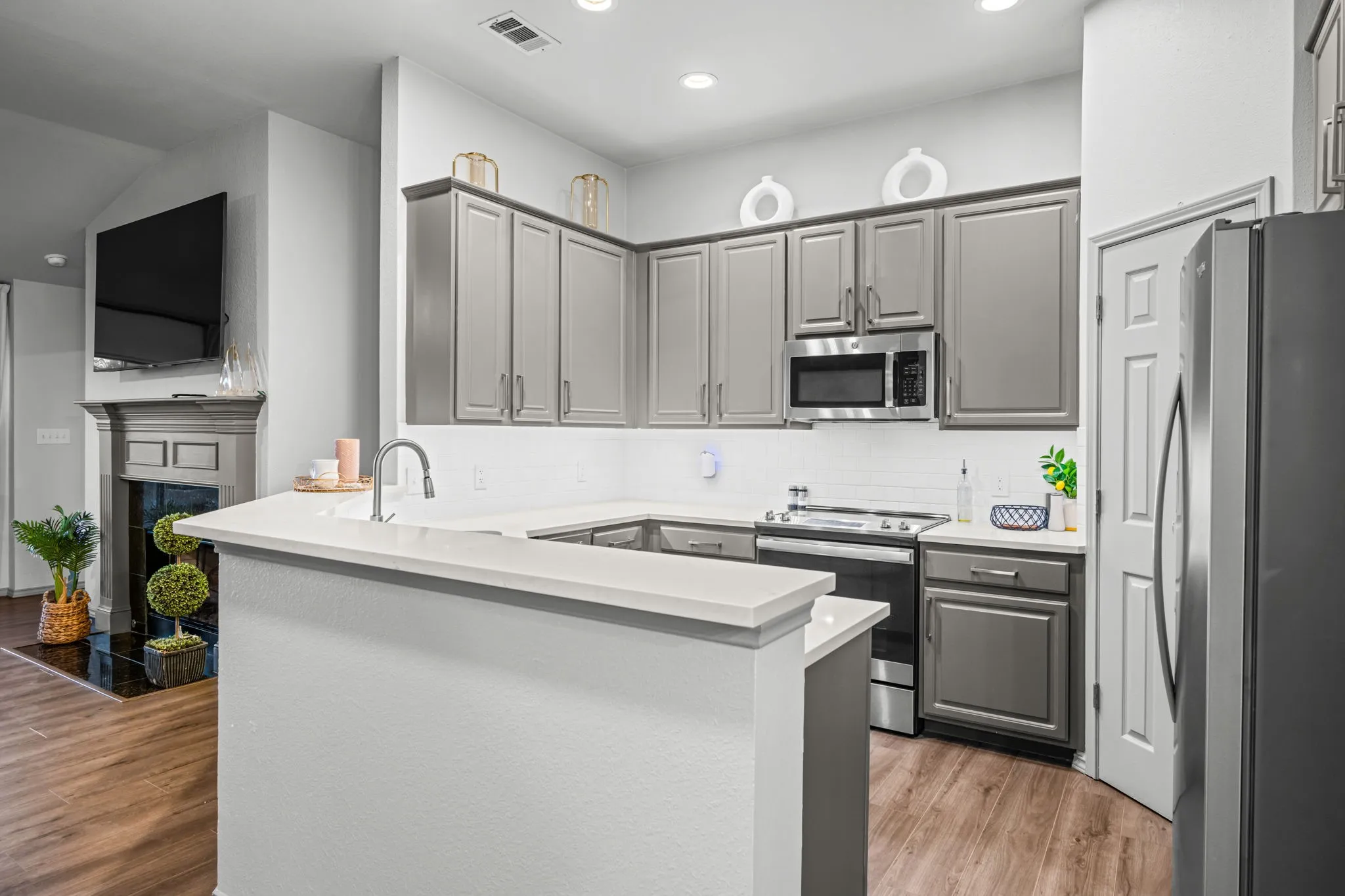 Open-concept kitchen featuring stainless steel appliances including an electric range