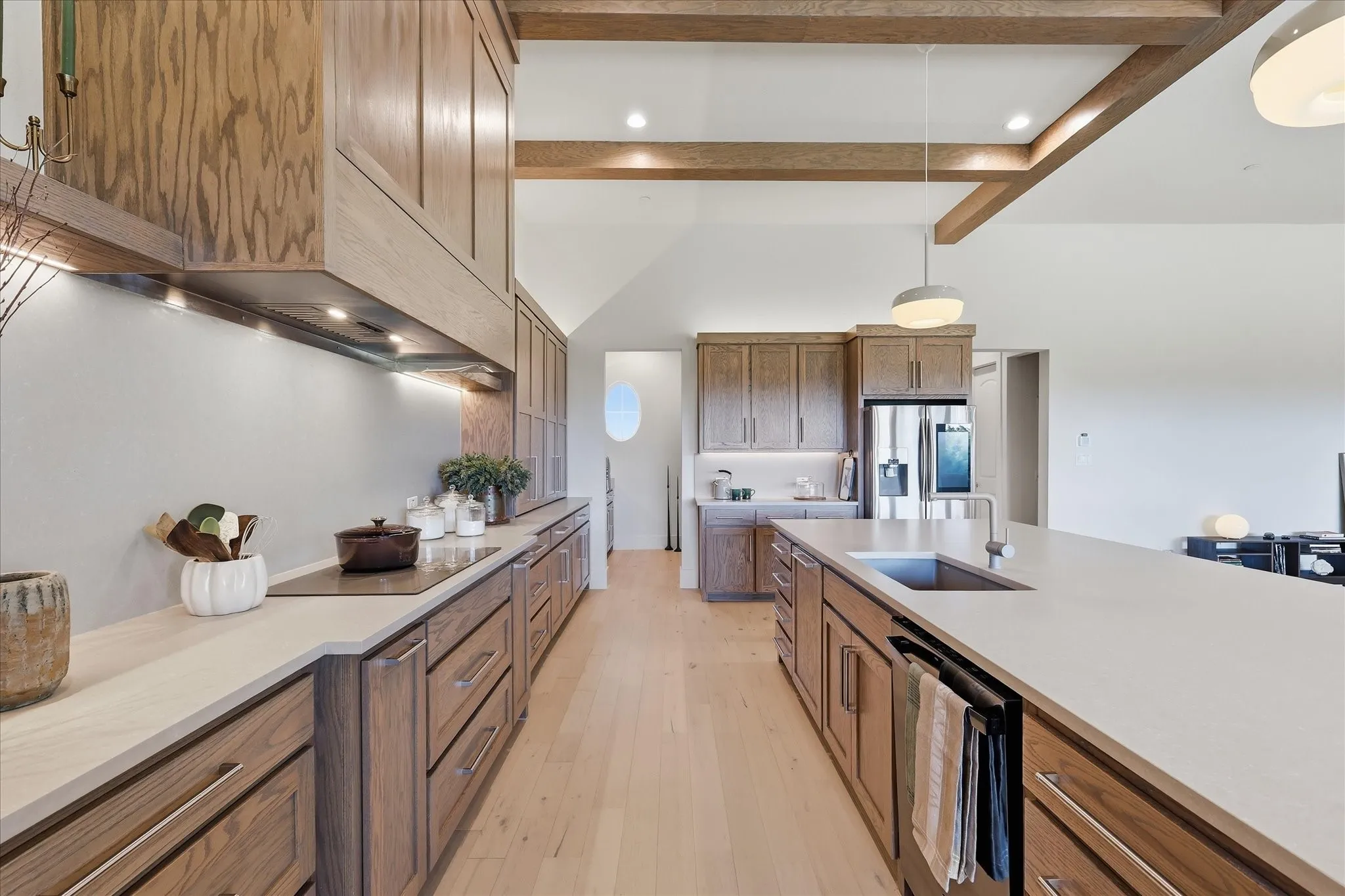 Custom kitchen with matching granite sink and faucet, undermounted and decorative ligting and Ivory White Honed quartz counters.