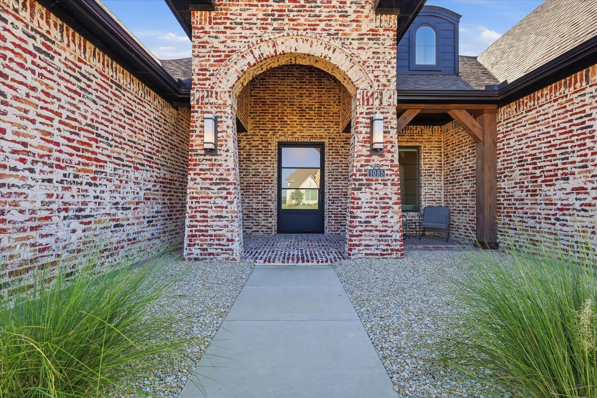 Luxurious metal front door sits adjacent to covered front patio.