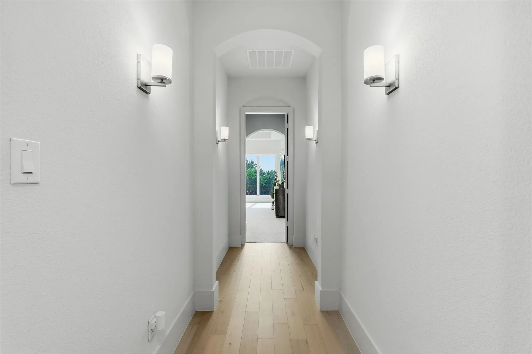 Private retreat to the primary wing with custom wall sconces and arched entryways