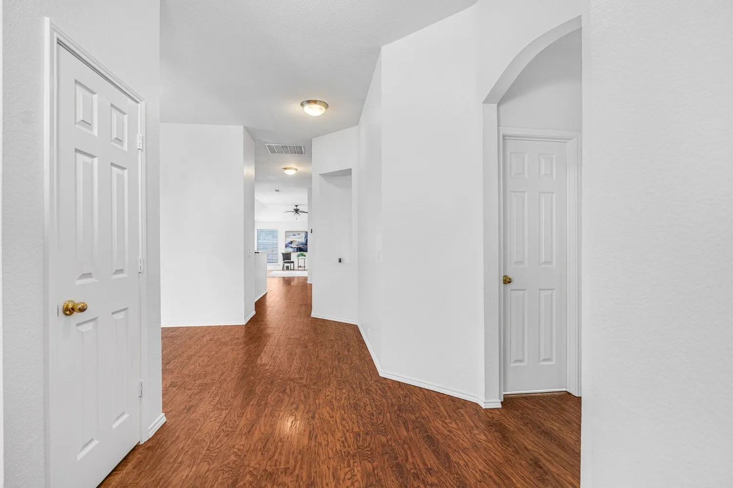 Hallway featuring wood-finish flooring, white walls, and recessed lighting