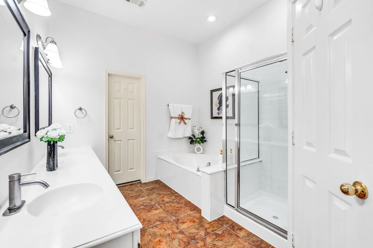 Bathroom featuring a white vanity with an integrated sink, brushed nickel faucet, and a framed mirror