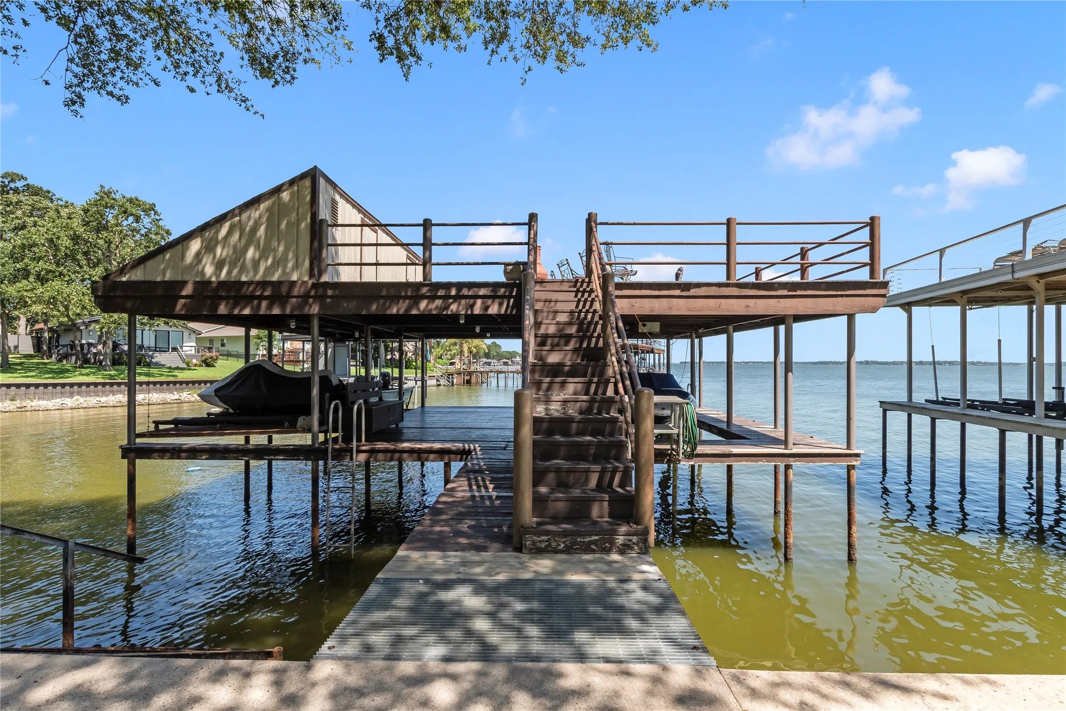 Boathouse with 2 boat slips, a pwc lift for two pods, and upper party deck storage room for lake toys.