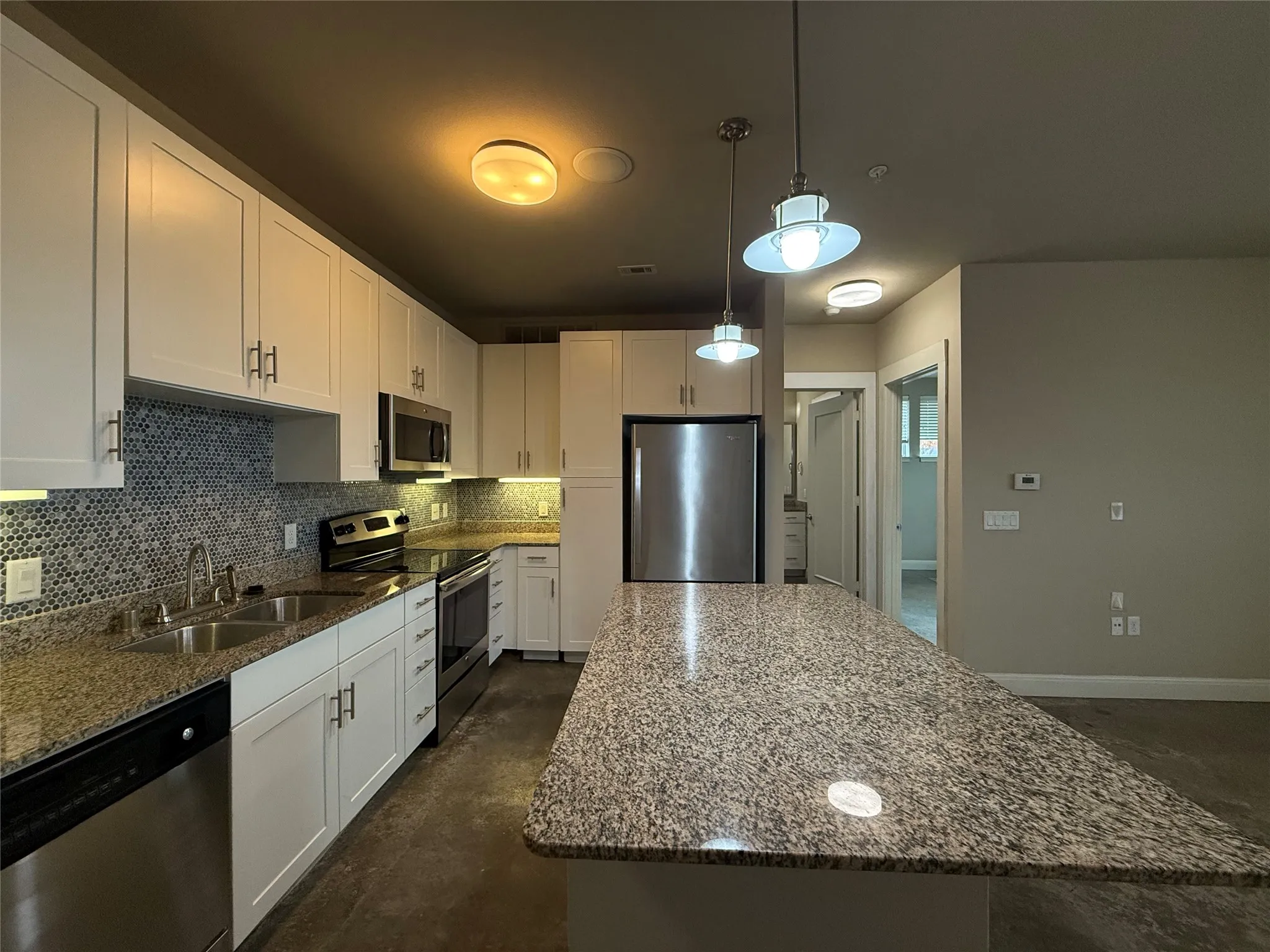 Kitchen island with a granite countertop and pendant lighting
