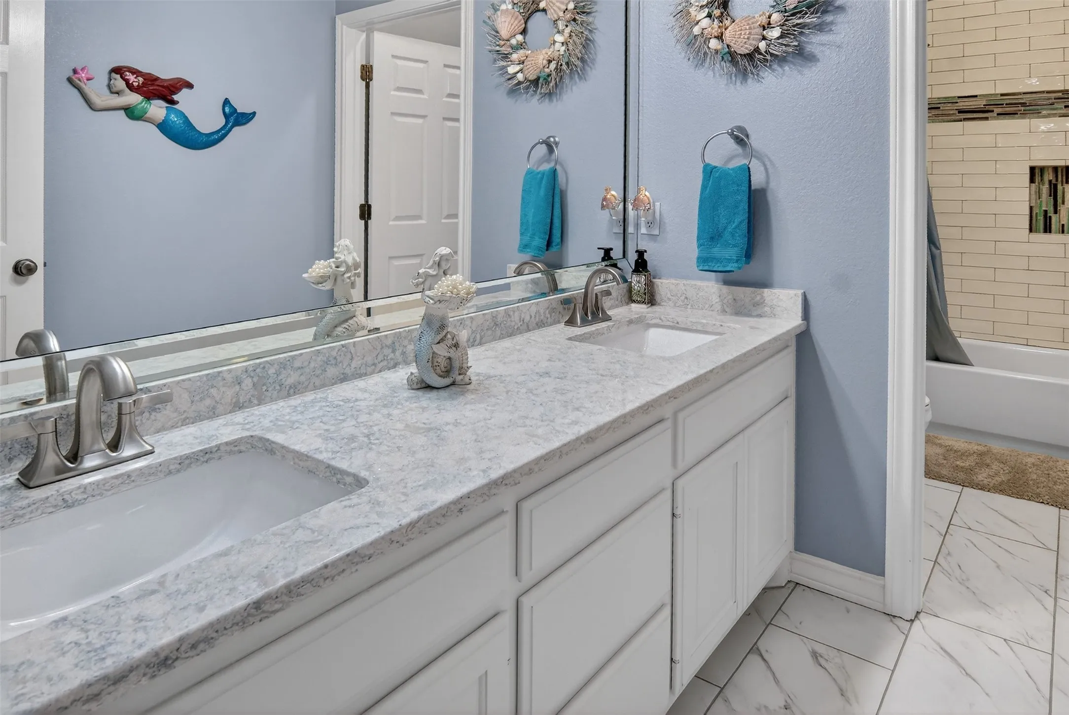 Second of three full bathrooms downstairs. Dual sinks and separate tub and toilet area are handy for multiple users at once.
