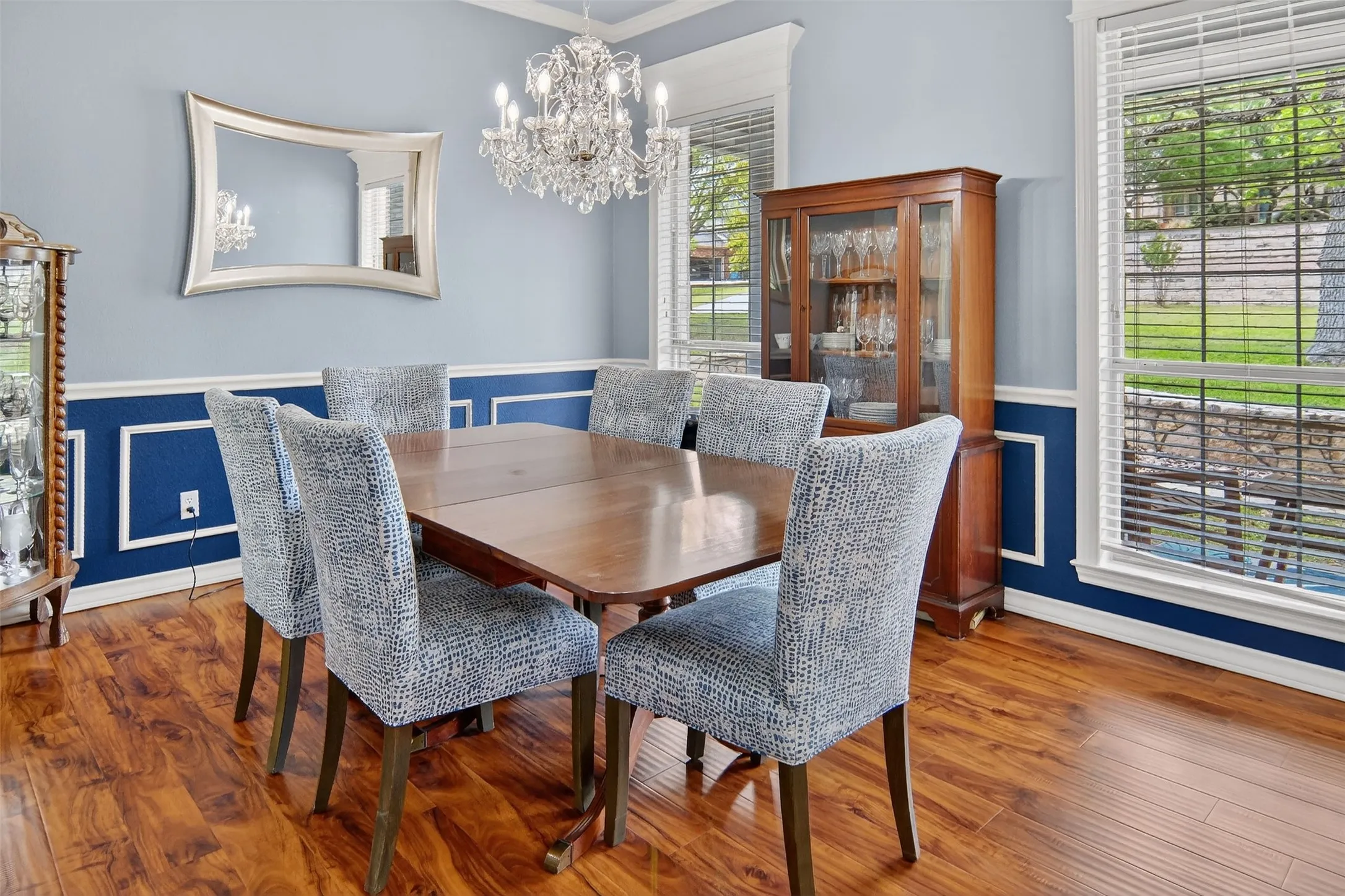 Spacious dining room with an elegant chandelier and wainscoting elevate every dinner.