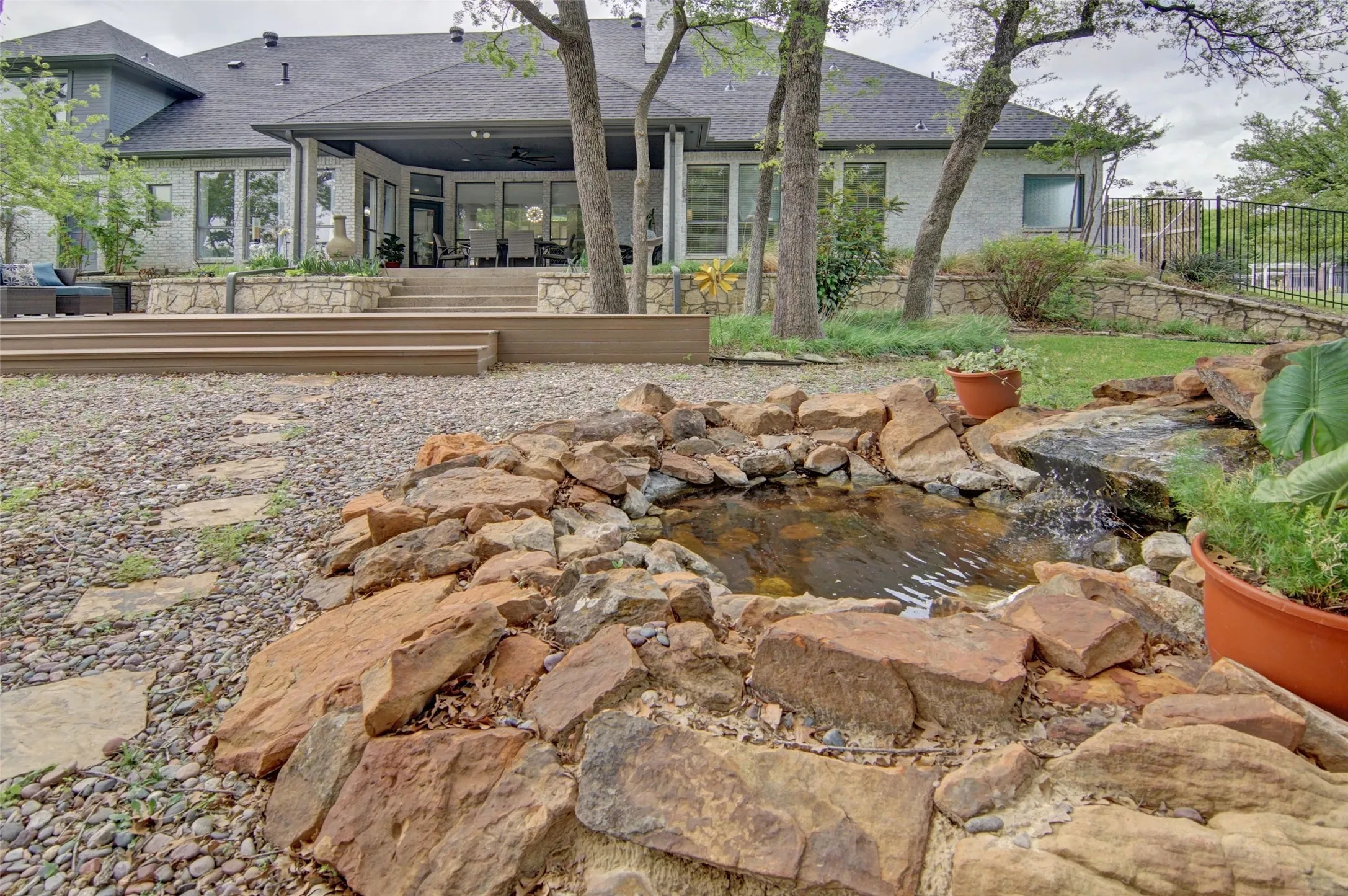 Beautifully landscaped backyard with peaceful, trickling water feature.