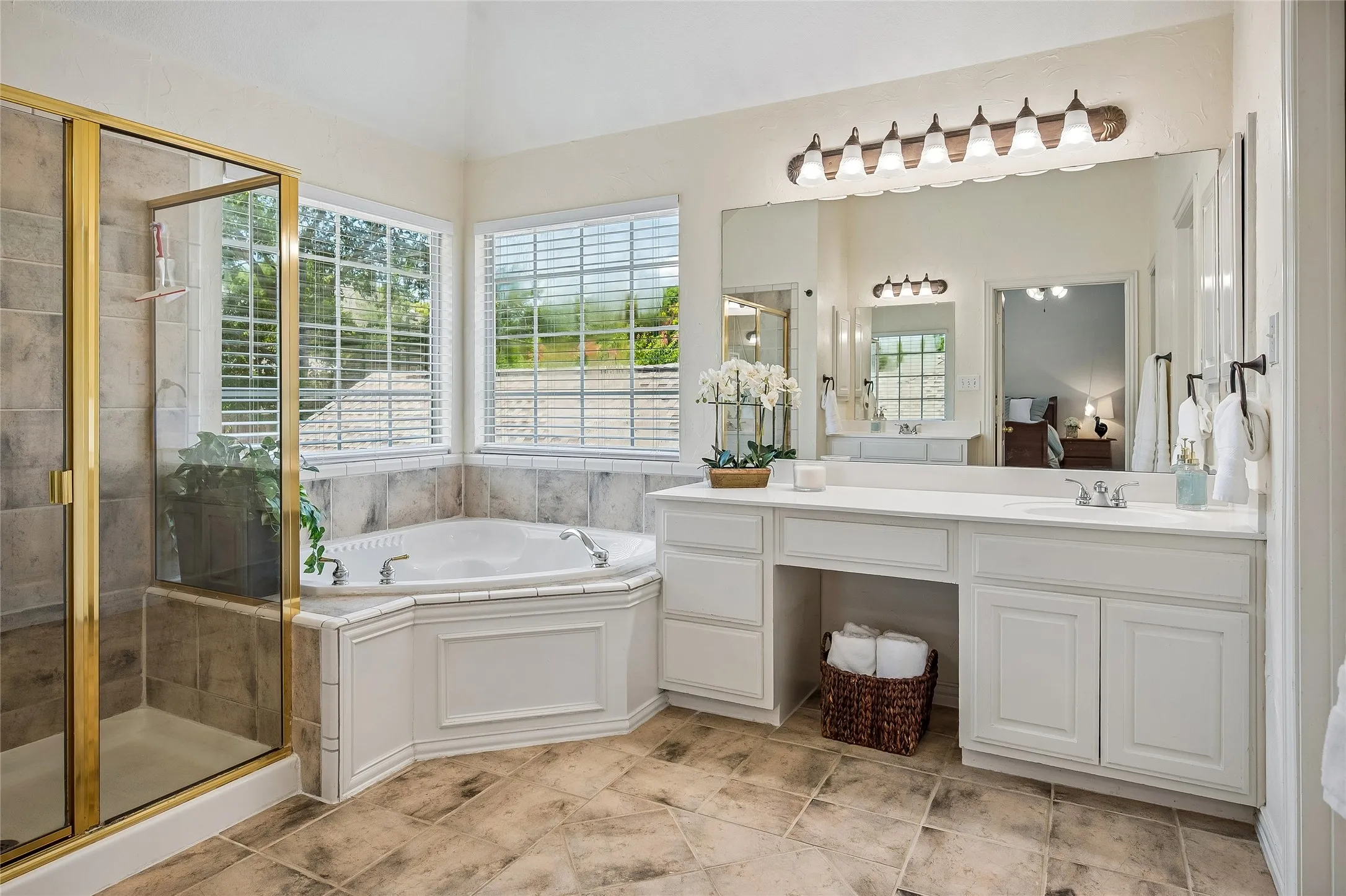Over sized shower plus a corner tub. Split vanities with lots of light.