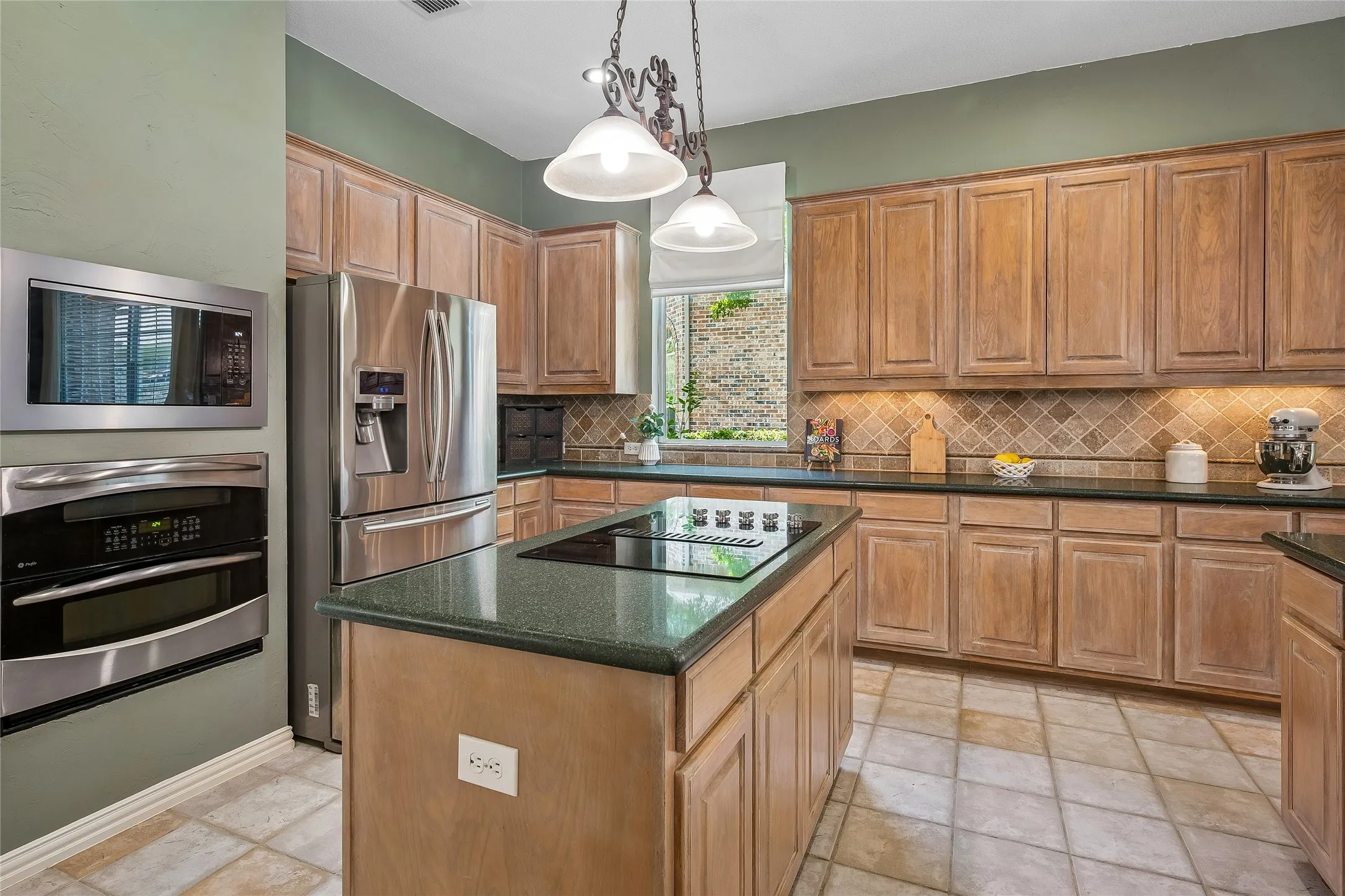Stainless steel double oven and cook top on island.