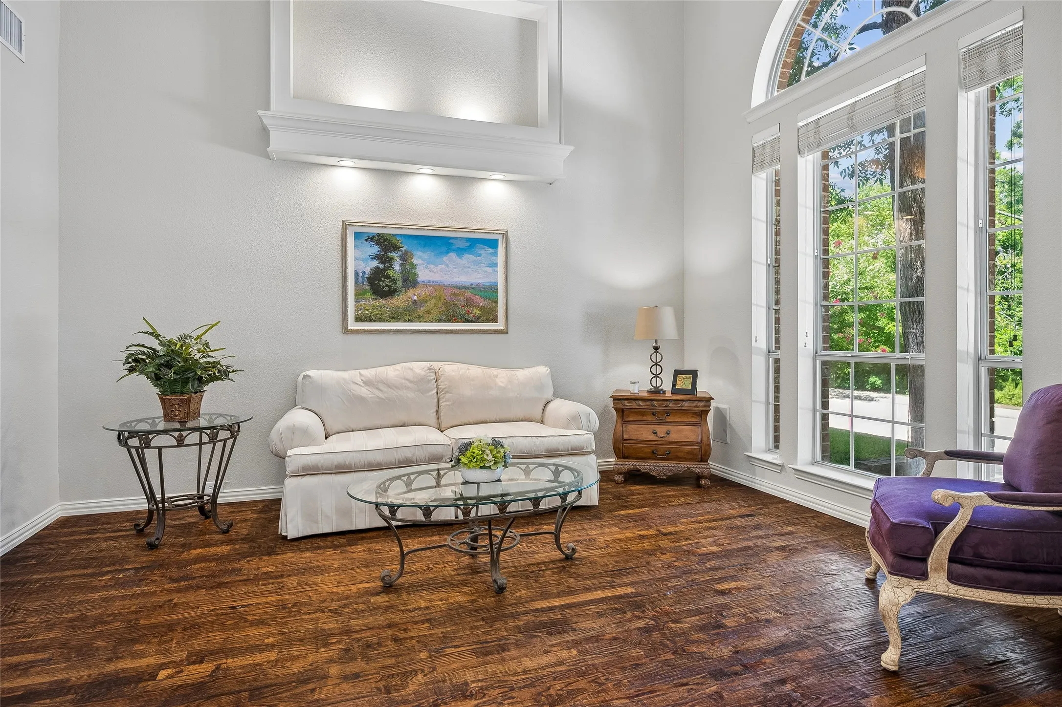 Two story formal living room, light and bright with windows and eyebrow window.