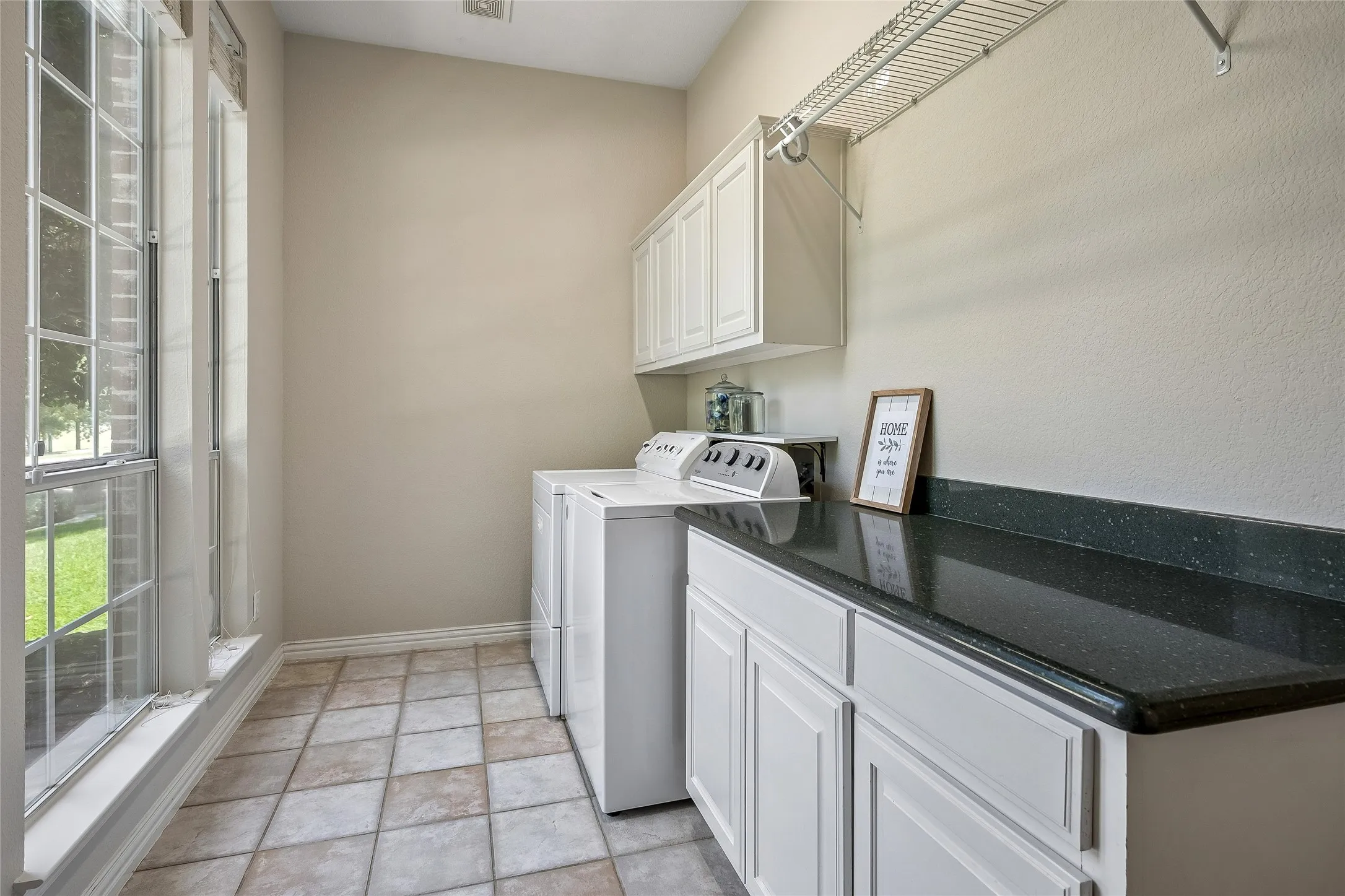 Large laundry room with built-in cabinets, long folding space as well as room for hanging clothes.