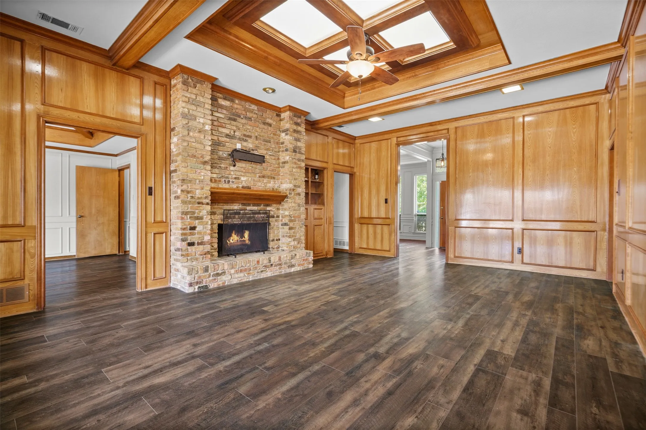 Oversized living room with built ins and a fireplace looking out to the pool