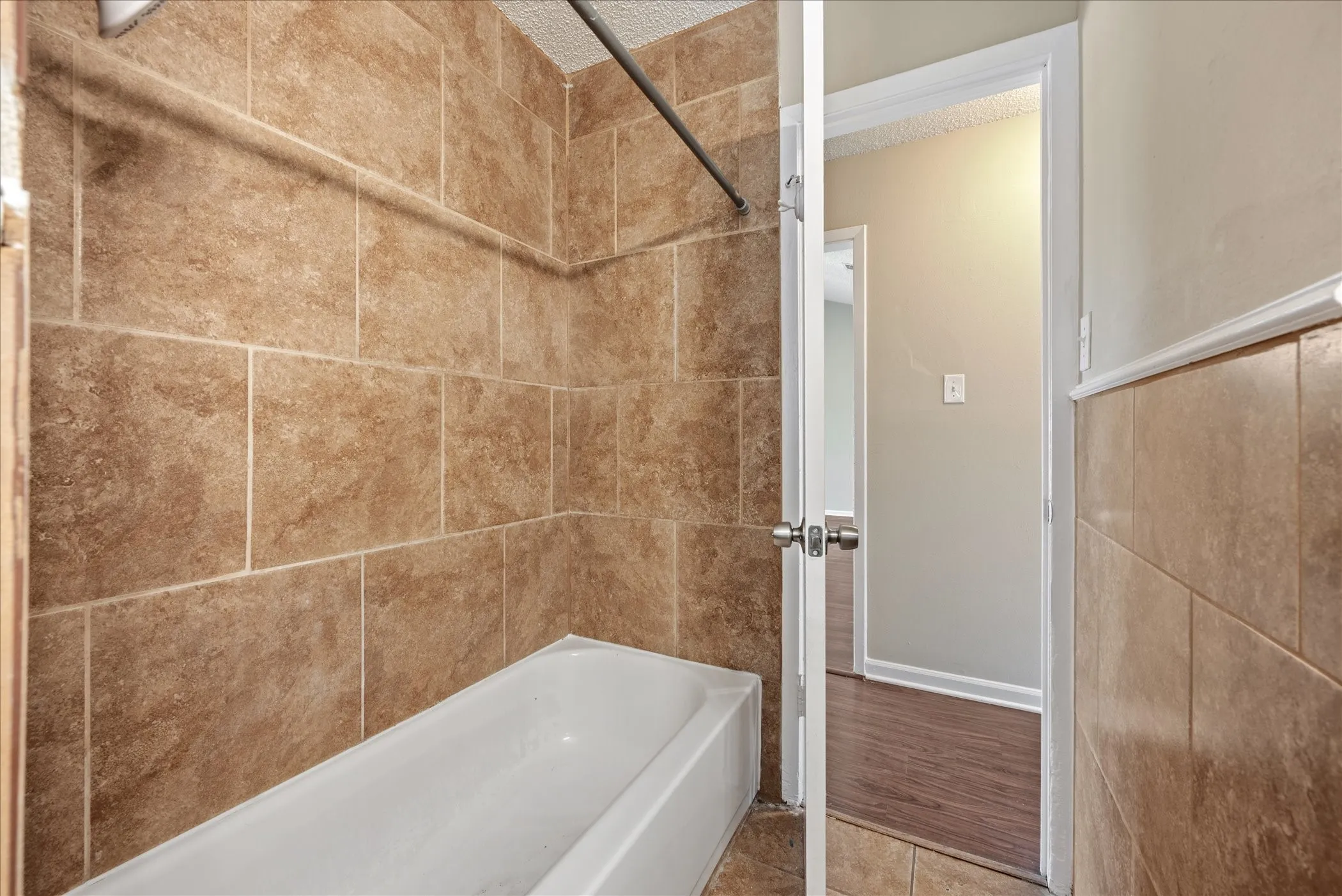 Bathtub with subway tile surround extending to the ceiling