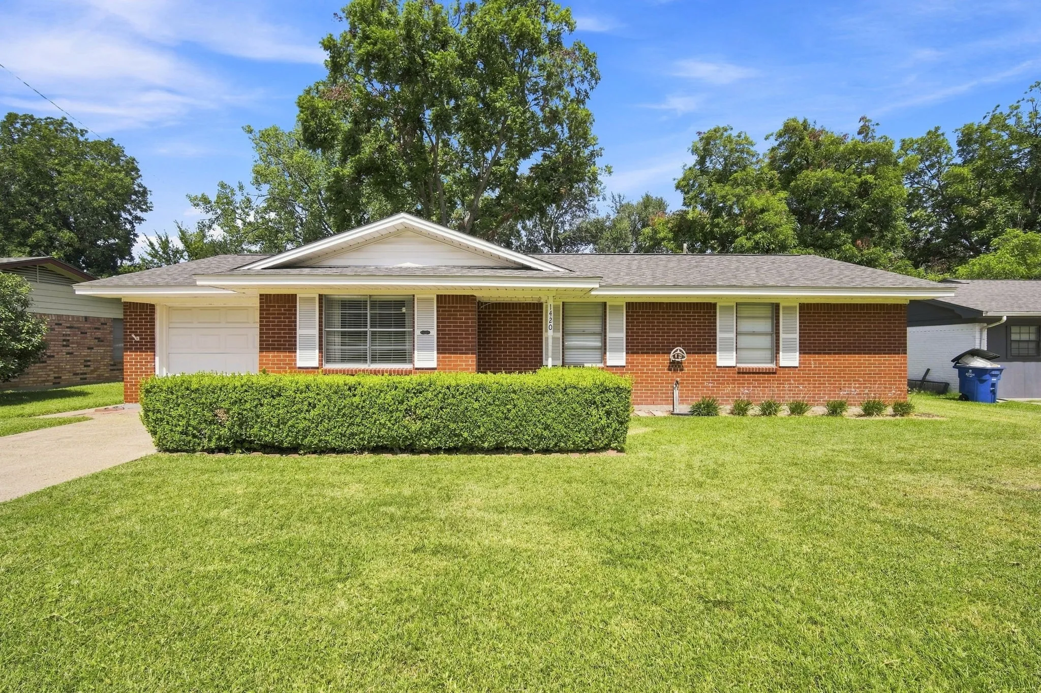 Brick ranch-style exterior featuring a prominent gable over the garage