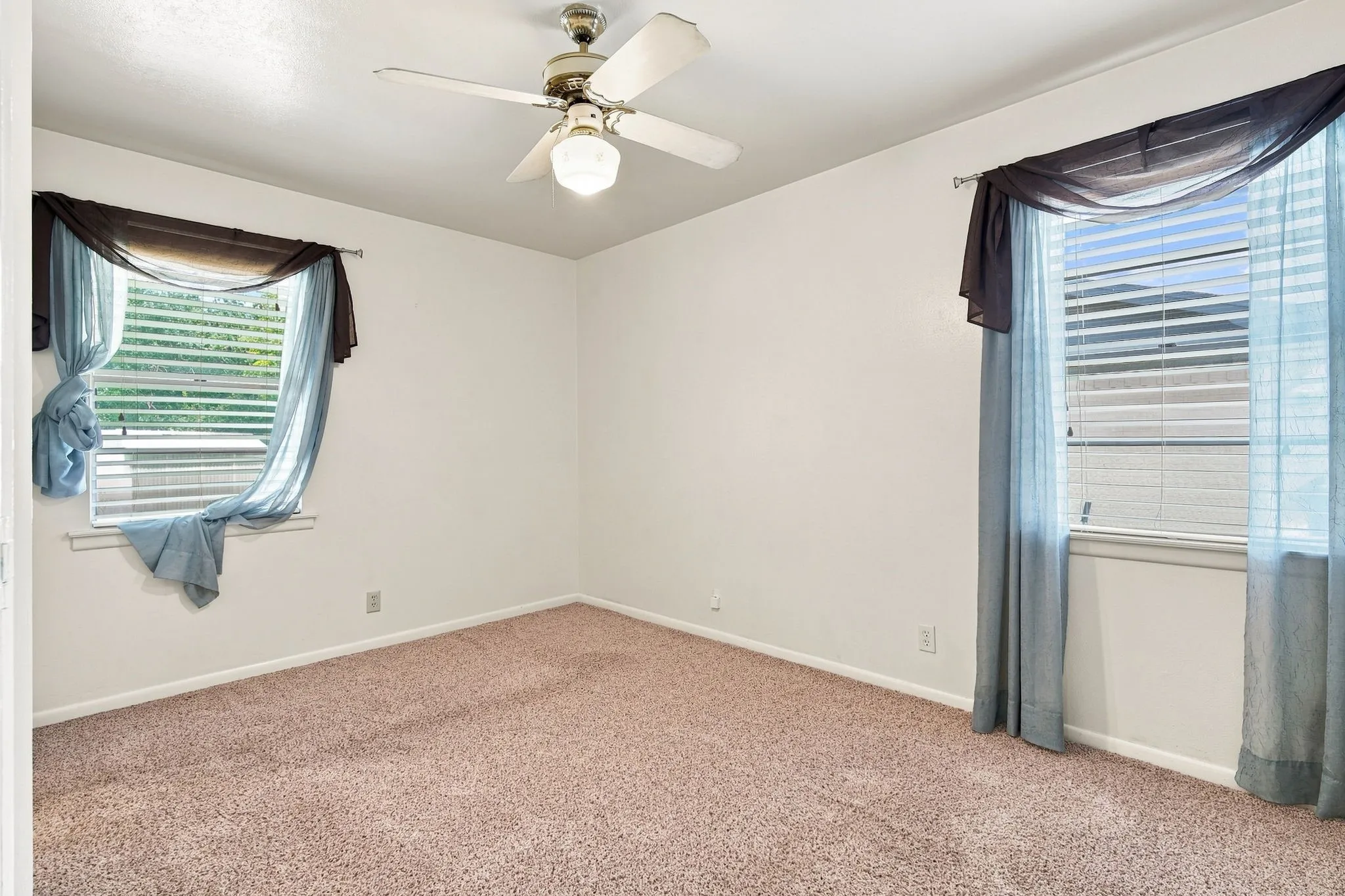 Bright interior room featuring neutral wall paint and textured carpet