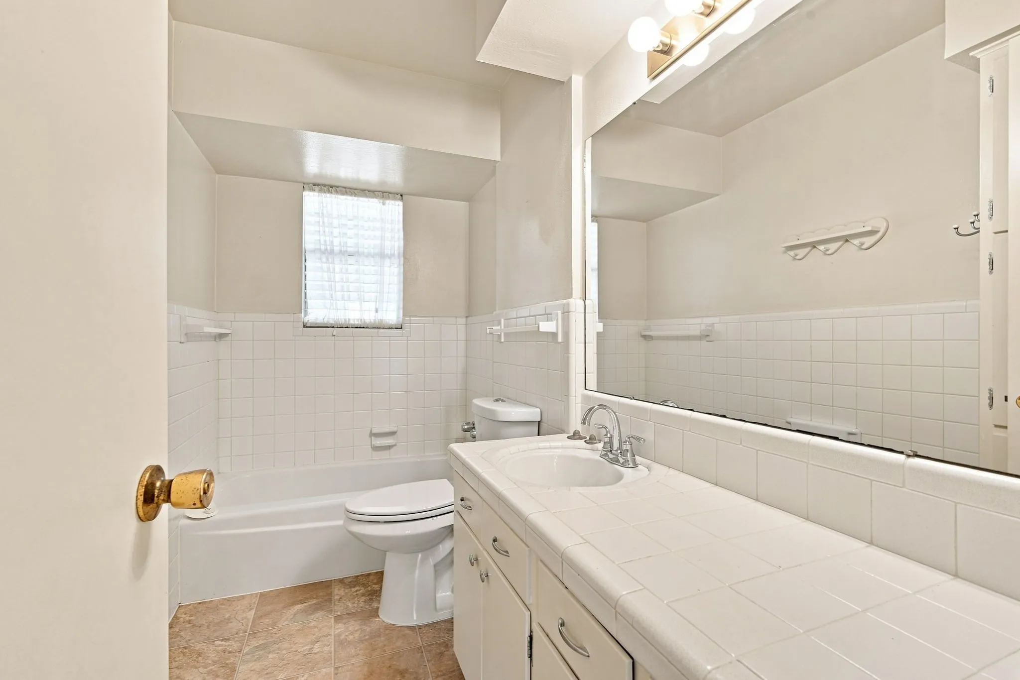 Bathroom vanity featuring a tile countertop, integrated sink, and chrome-finish faucet