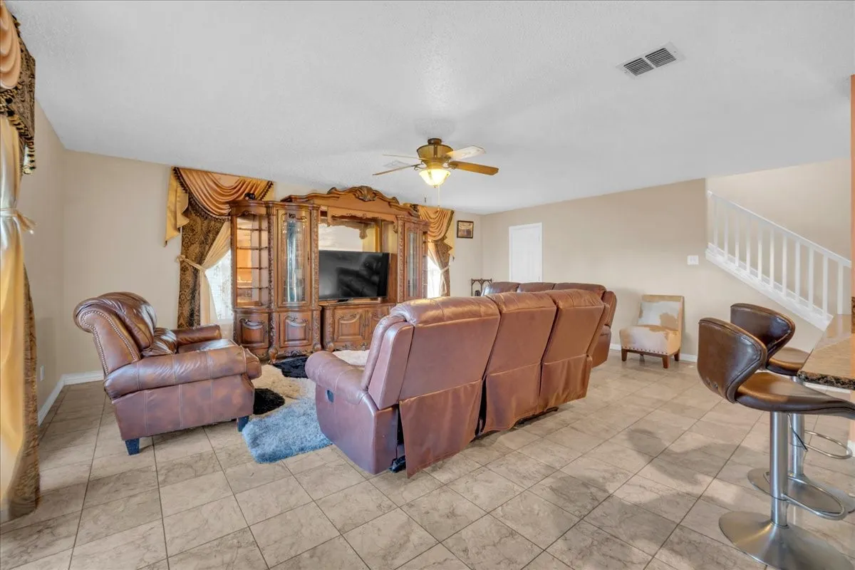 Tiled flooring throughout the main living space with a ceiling fan
