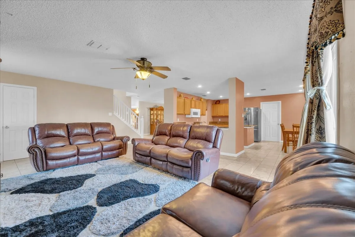 Open-concept living space featuring ceramic tile flooring, a ceiling fan, and recessed lighting
