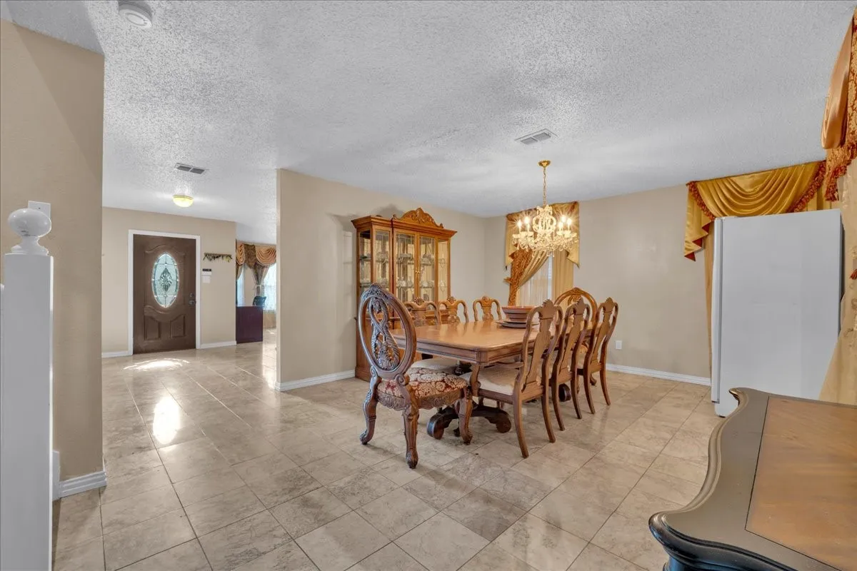 Tile flooring throughout, recessed lighting, and a chandelier fixture