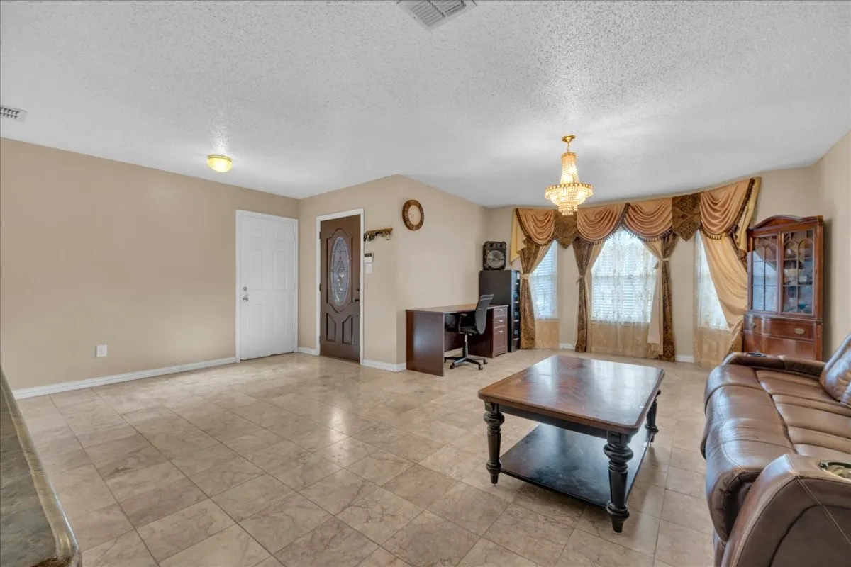 Tiled flooring throughout, recessed lighting, and an ornate chandelier