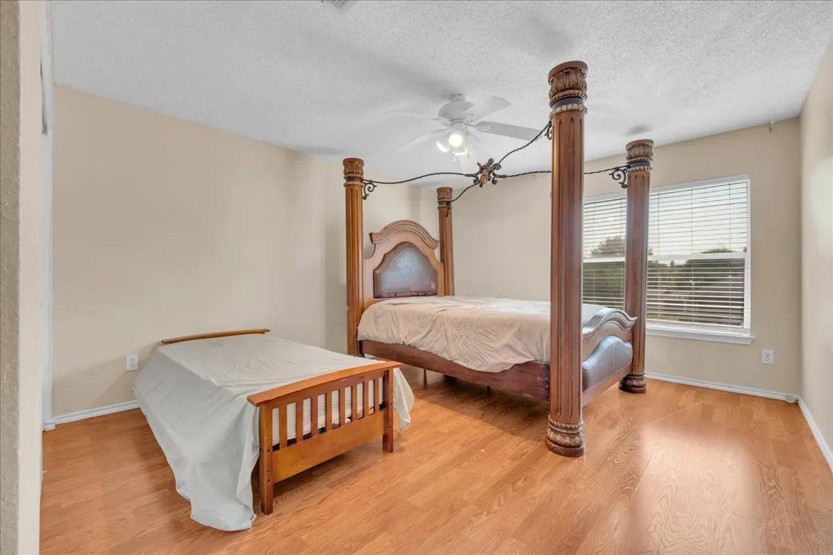 Wood-finish flooring, neutral wall tones, and a ceiling fan