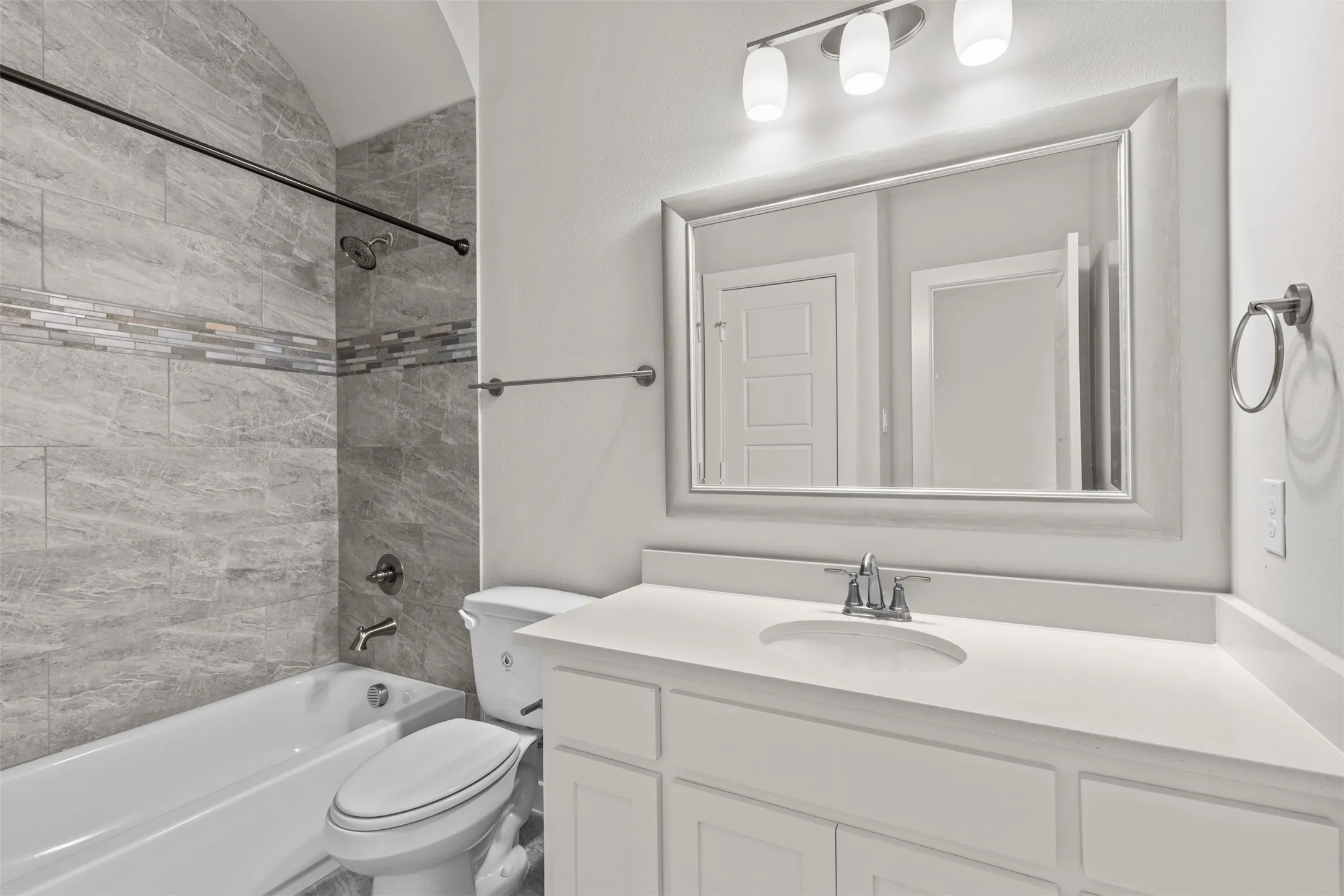 Secondary bath upstairs features tile flooring, tub/shower combo and quartz countertops