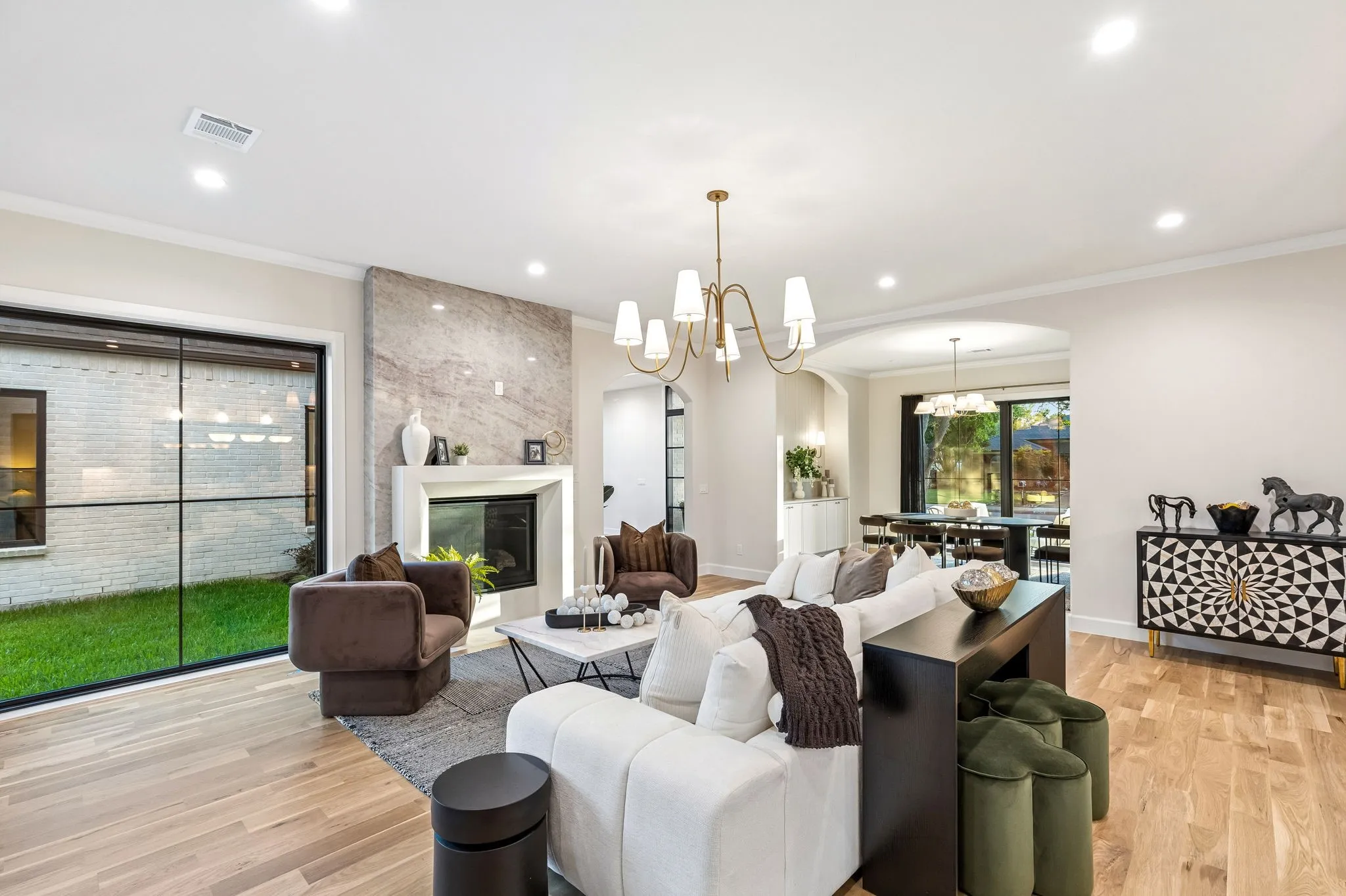 Living room with fireplace flanked by Taj Mahal tile with a view into the formal dining space
